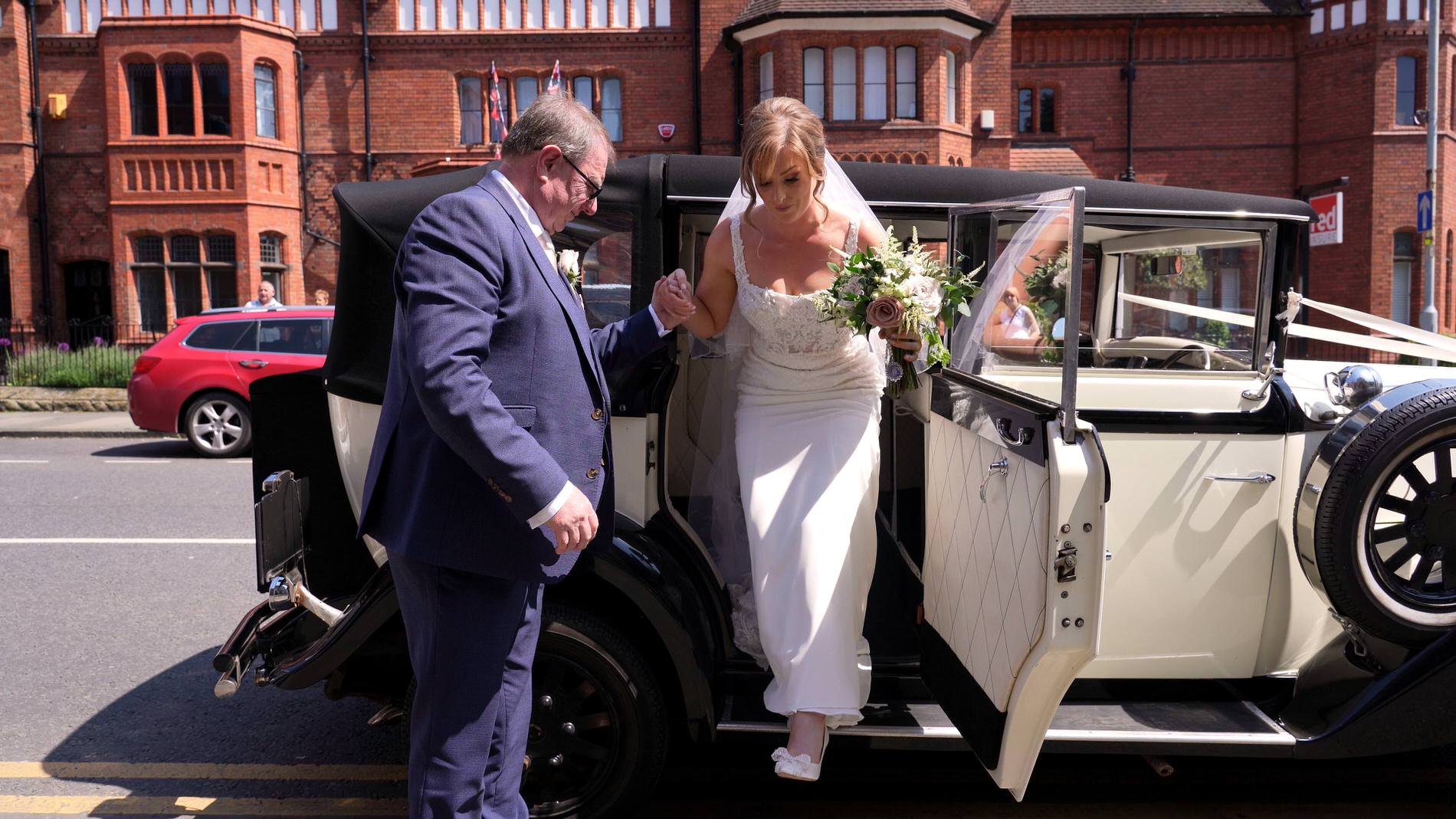 the bride steps out of her Bespoked wedding car outside St Werburghs Chester