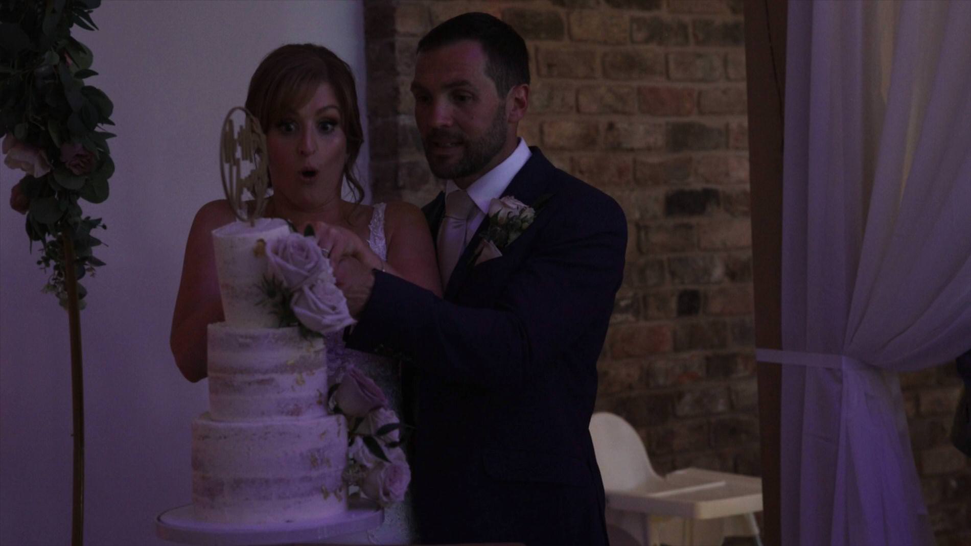 the couple nearly knock the cake over during the cake cut