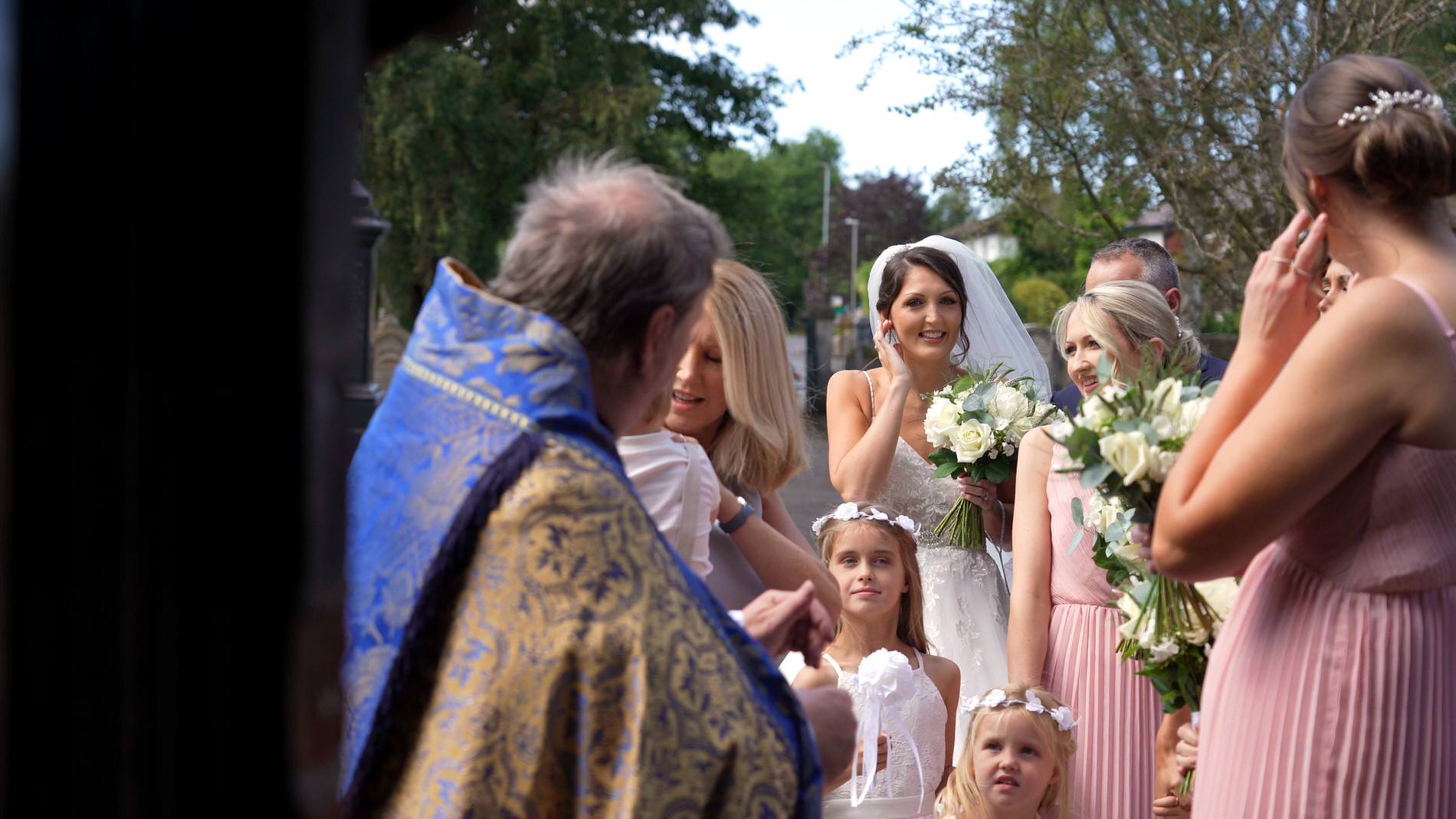 a bride waits outside st mary the virgin church in rufford