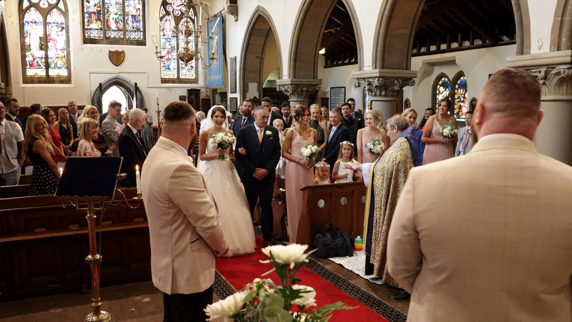 a bride walks down the aisle at st mary the virgin church in rufford