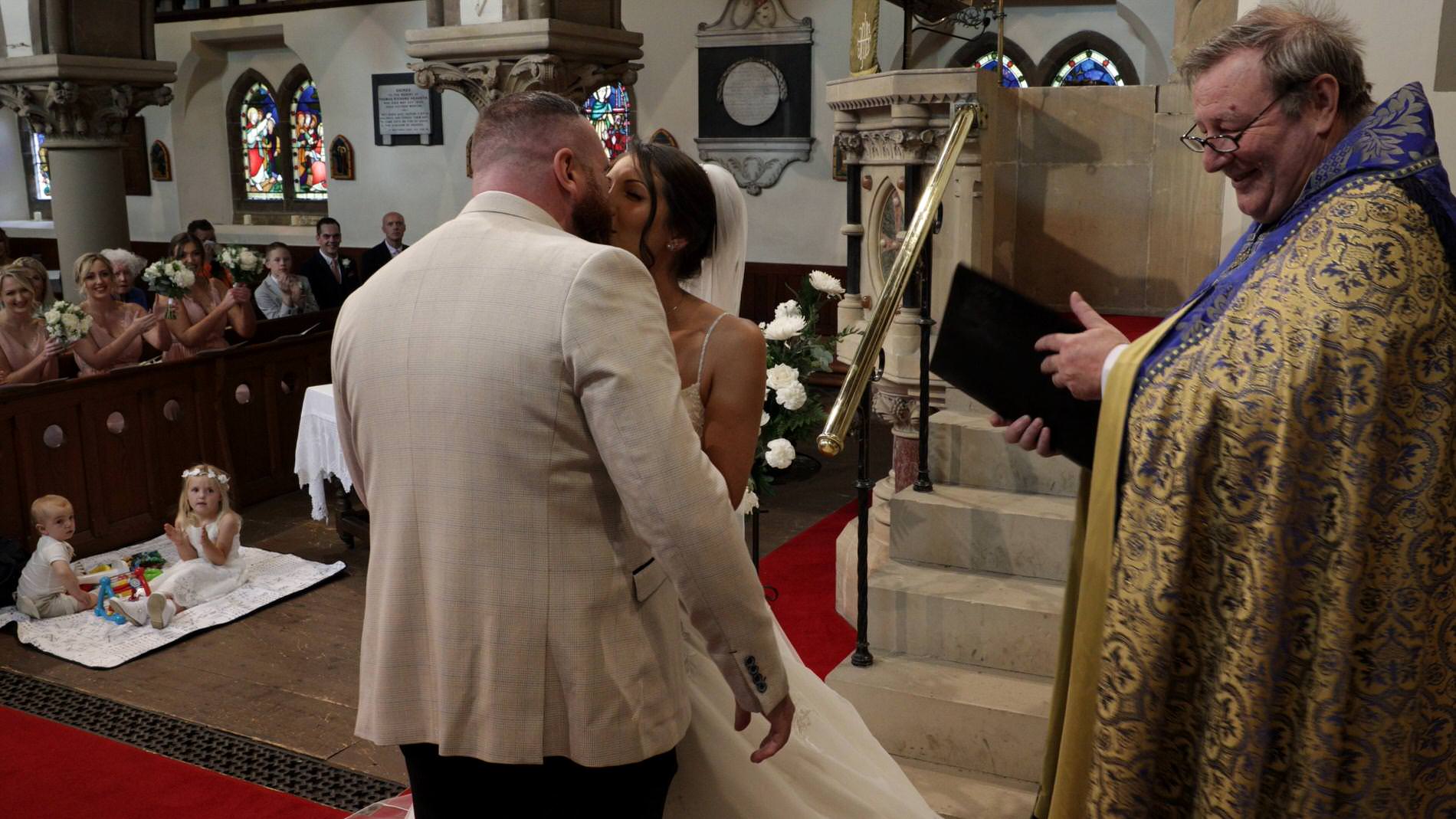 a couple kiss during a ceremony at st mary the virgin church in rufford