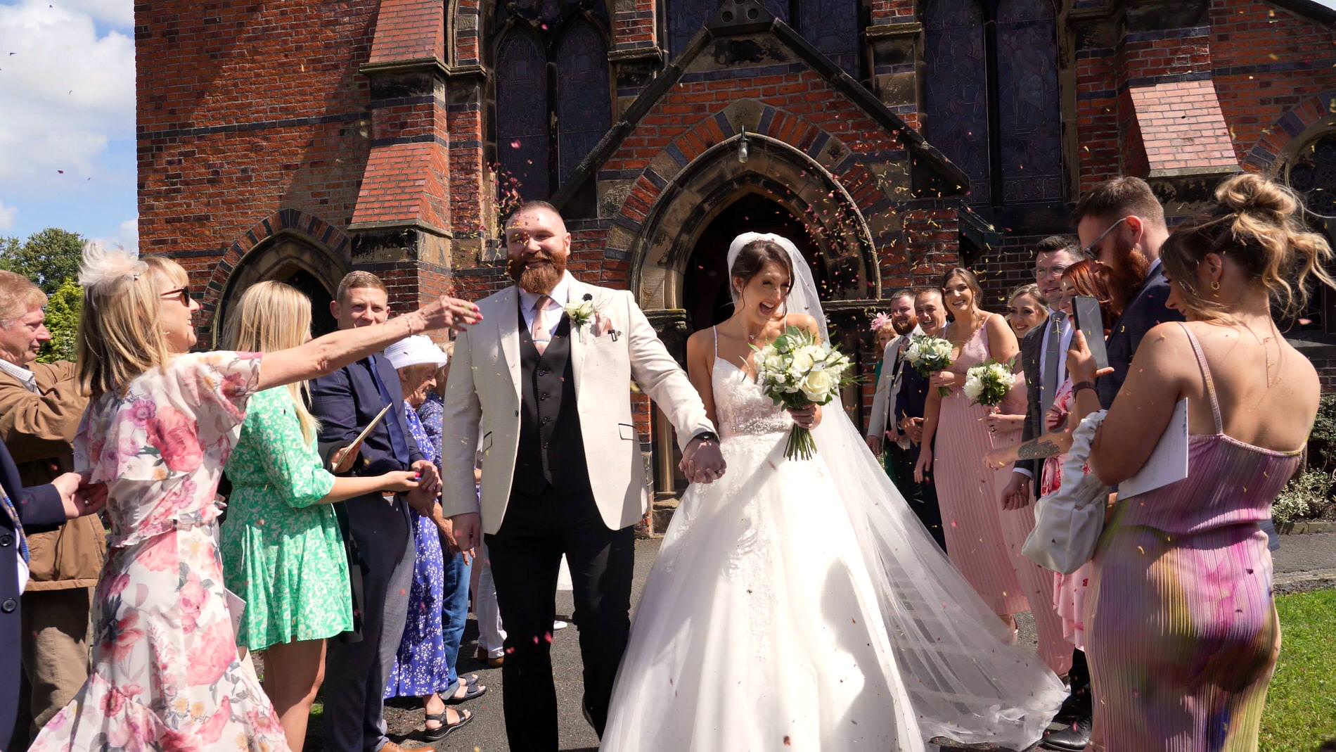 a couple laugh during a confetti shot outside st mary the virgin church in rufford
