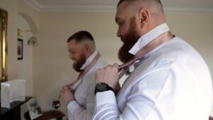 a groom and best man struggle to tie their wedding ties