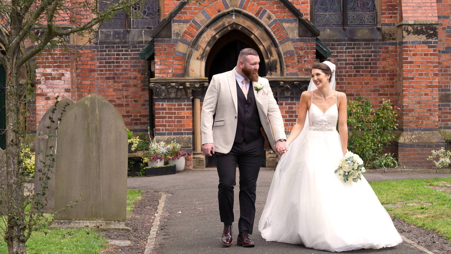 the couple walk down the path outside st mary the virgin church in rufford