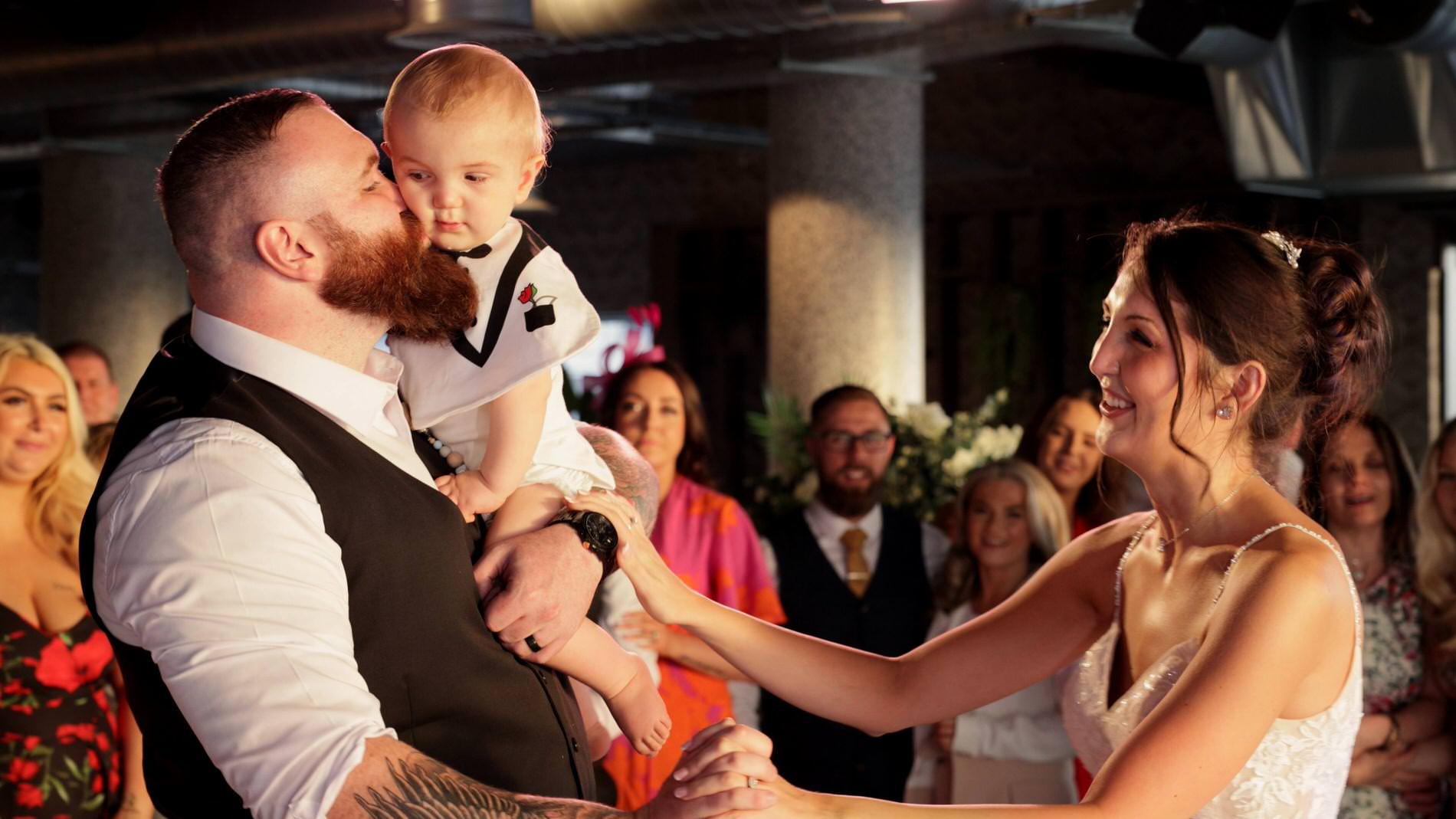 the couple dance with their son during their reception at The Waterfront Southport