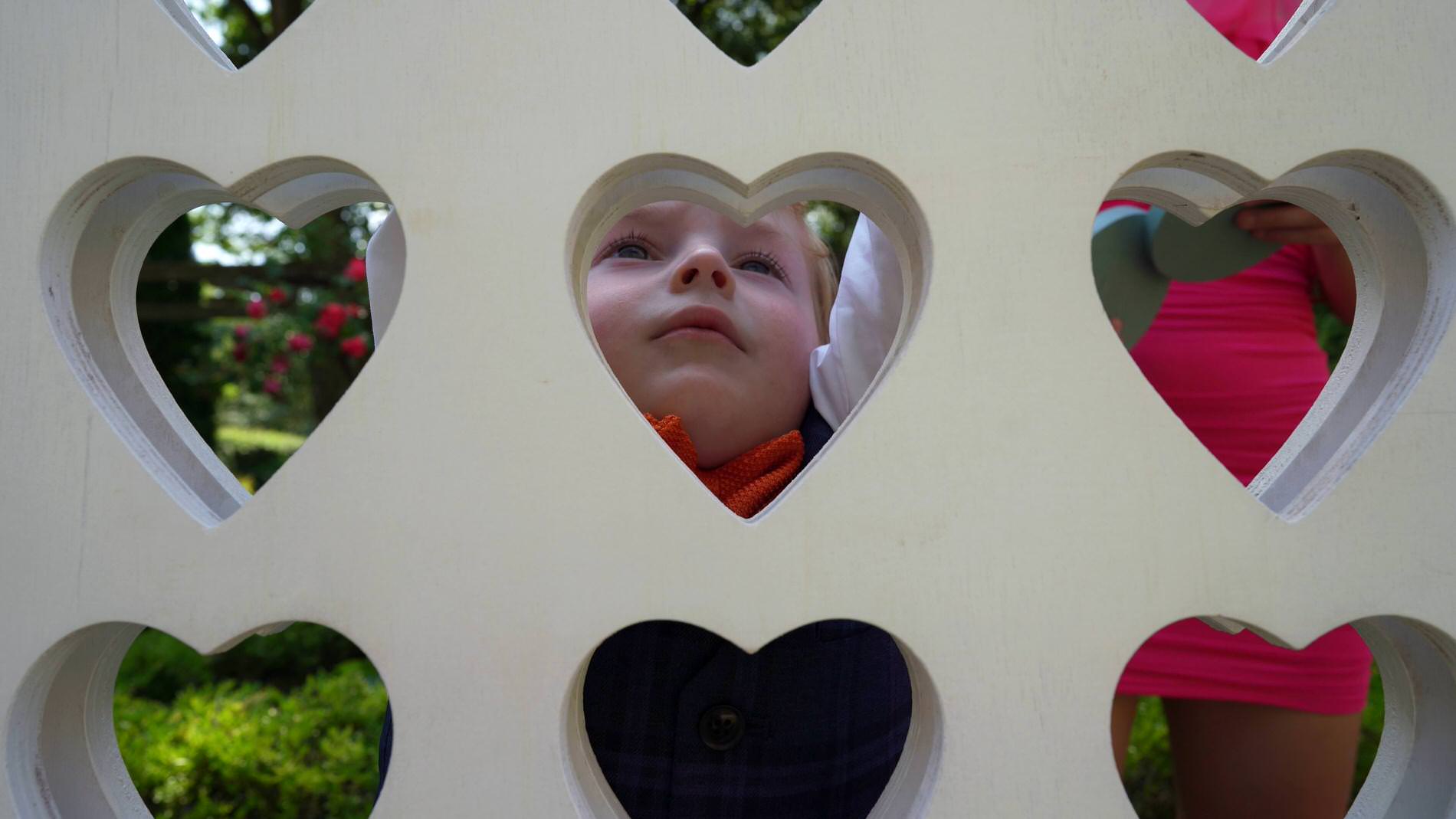 a page boy plays a heart connect 4 garden game in Cheshire
