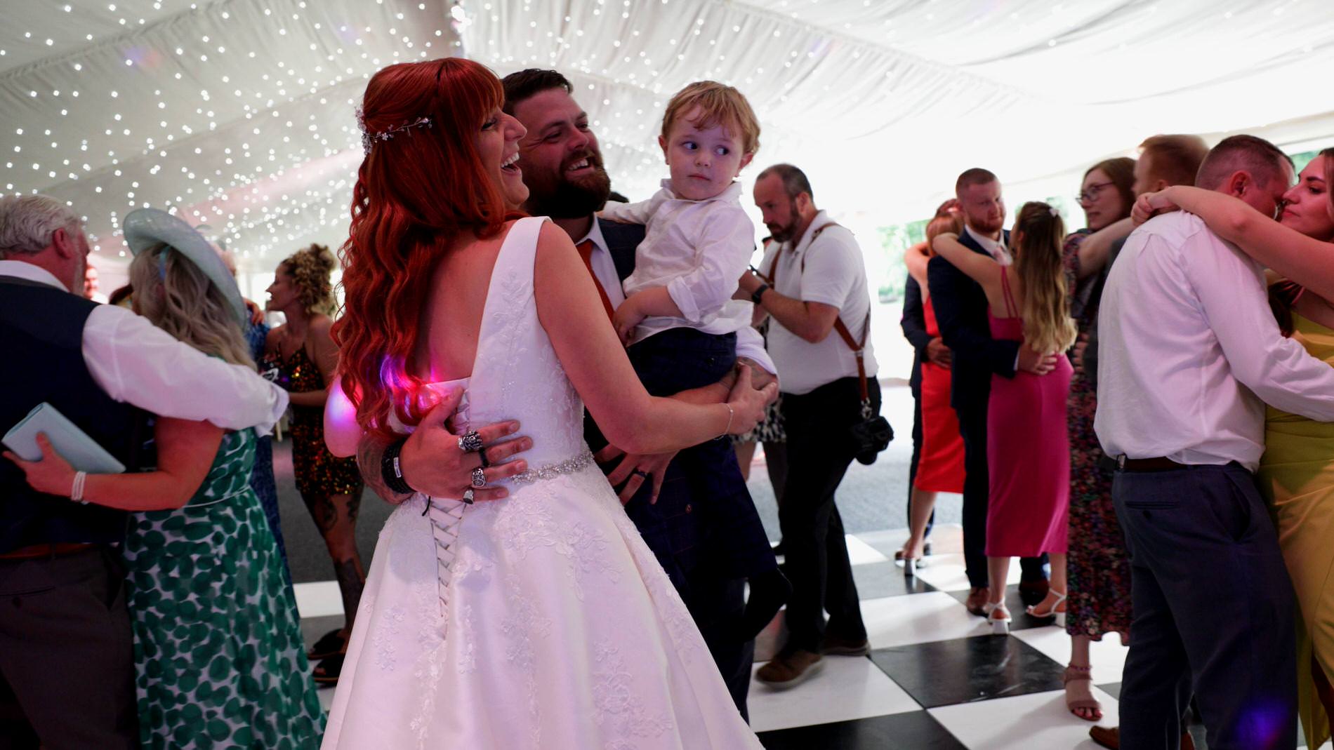 the couple share their first dance with their son at a wedding in Nunsmere hall