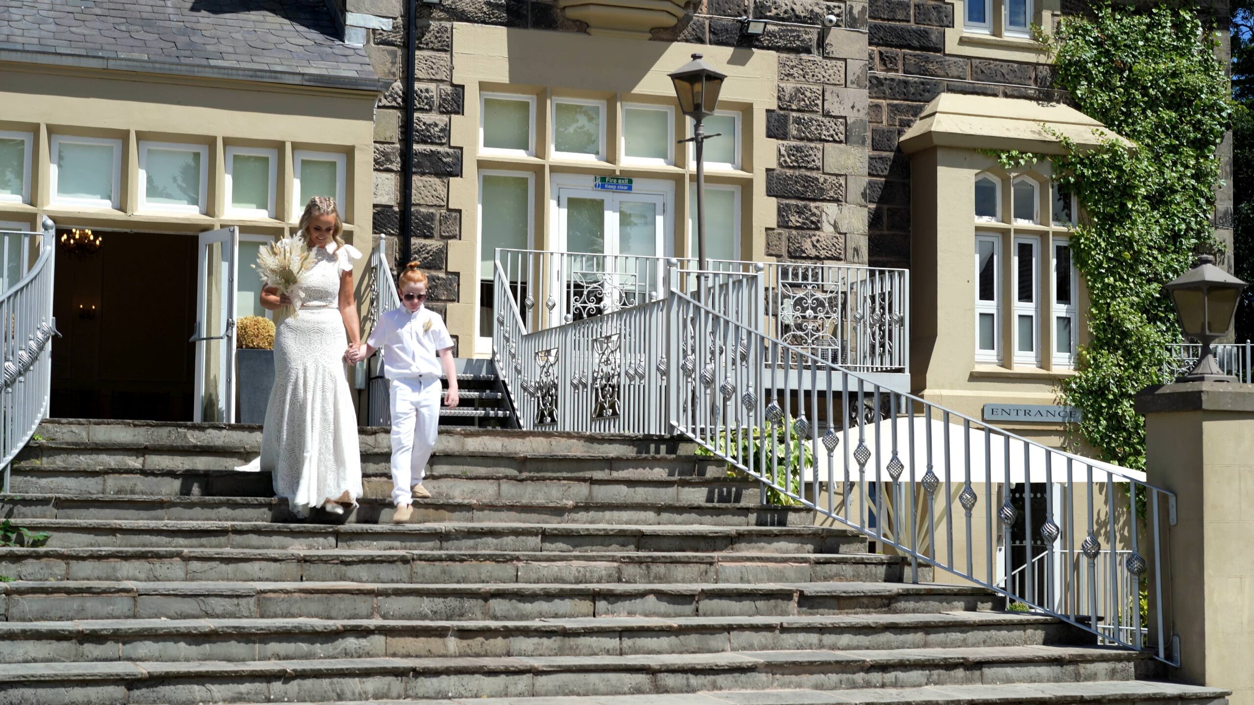 a bride walks down the stairs at west tower with her youngest son