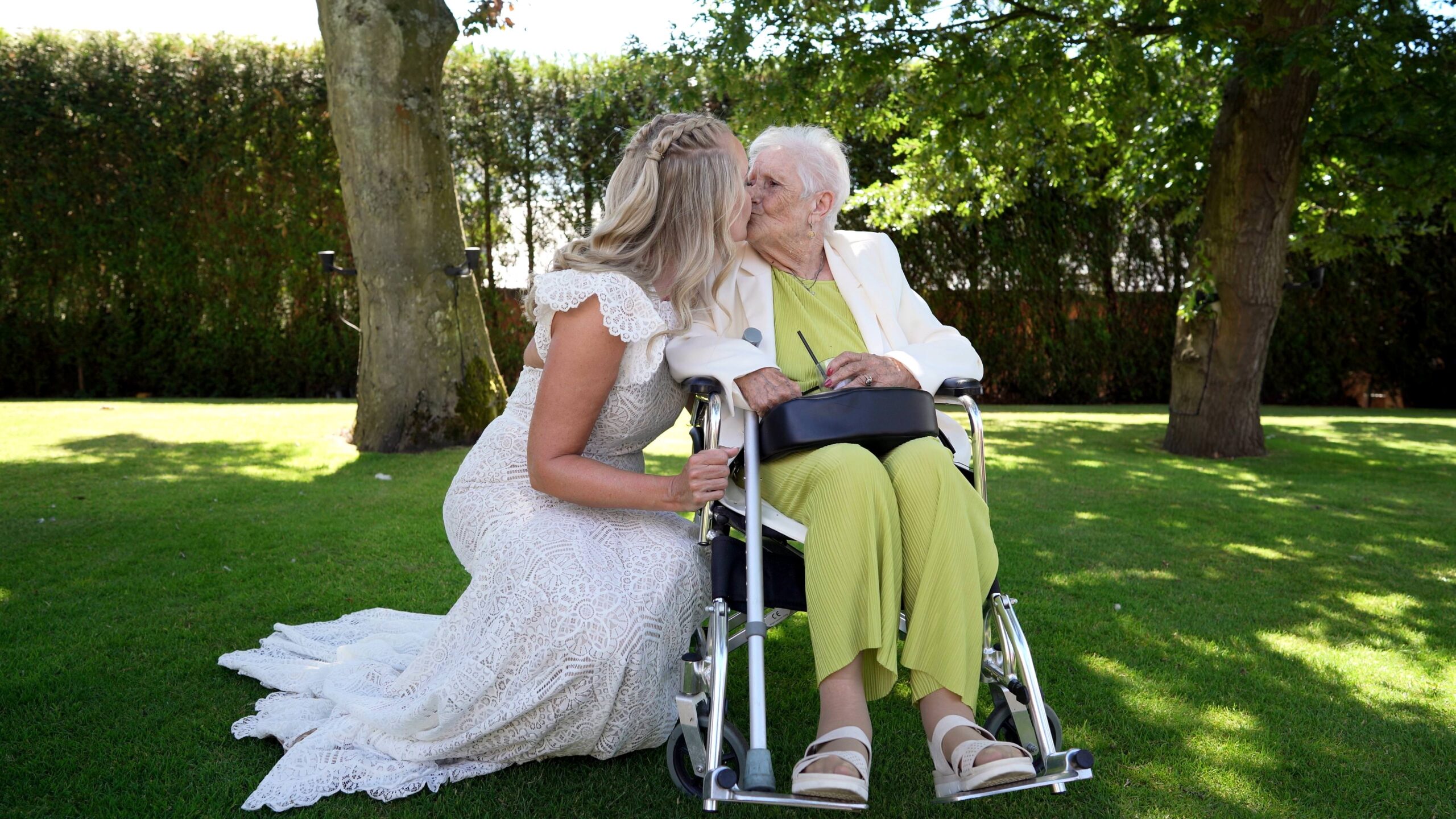a bride sits by her Nan and gives her a kiss