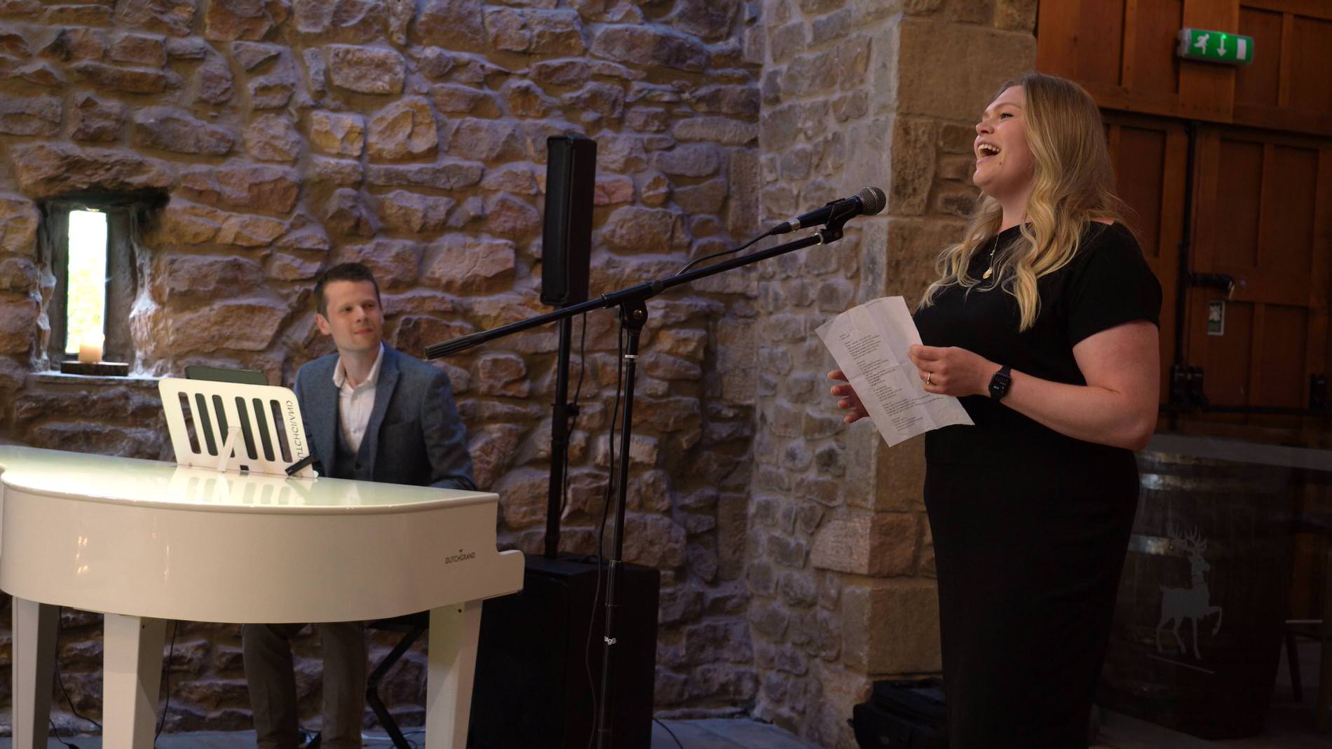 a wedding guests sings with James Roscoe playing piano