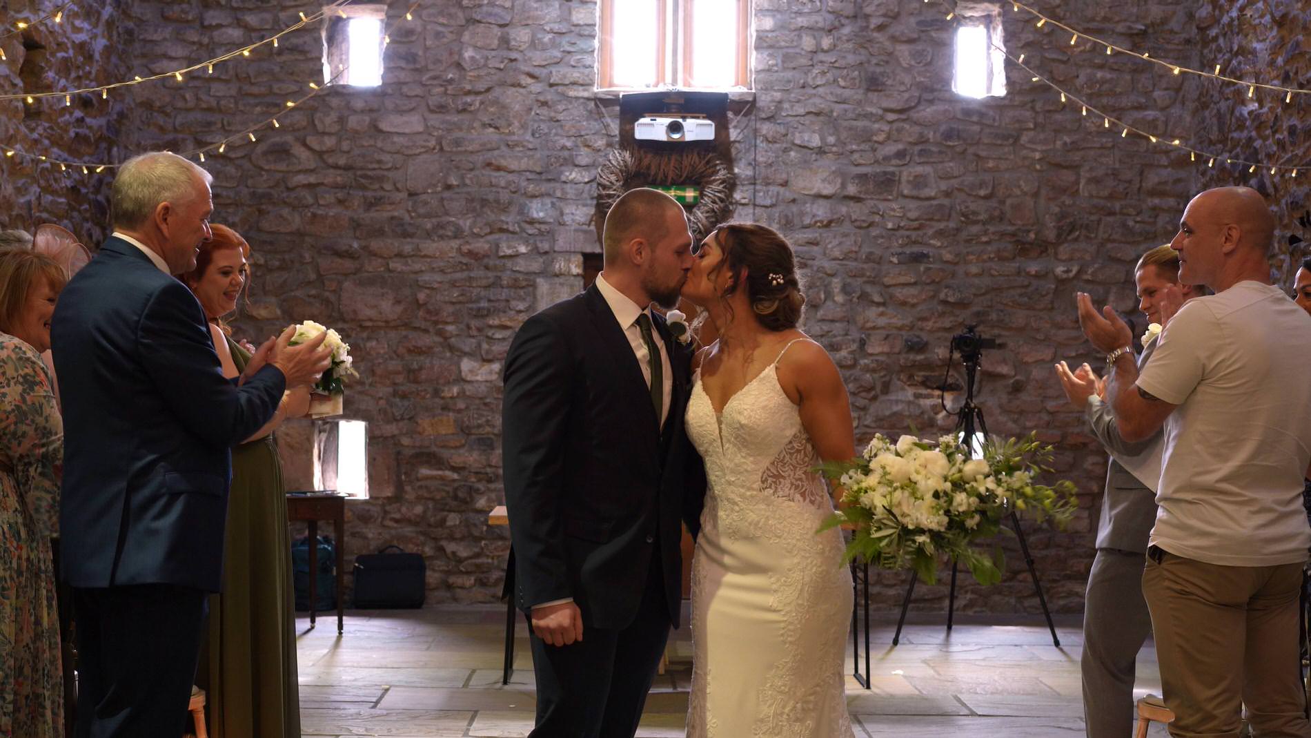 the bride and groom kissing walking back down the aisle at Browsholme Hall