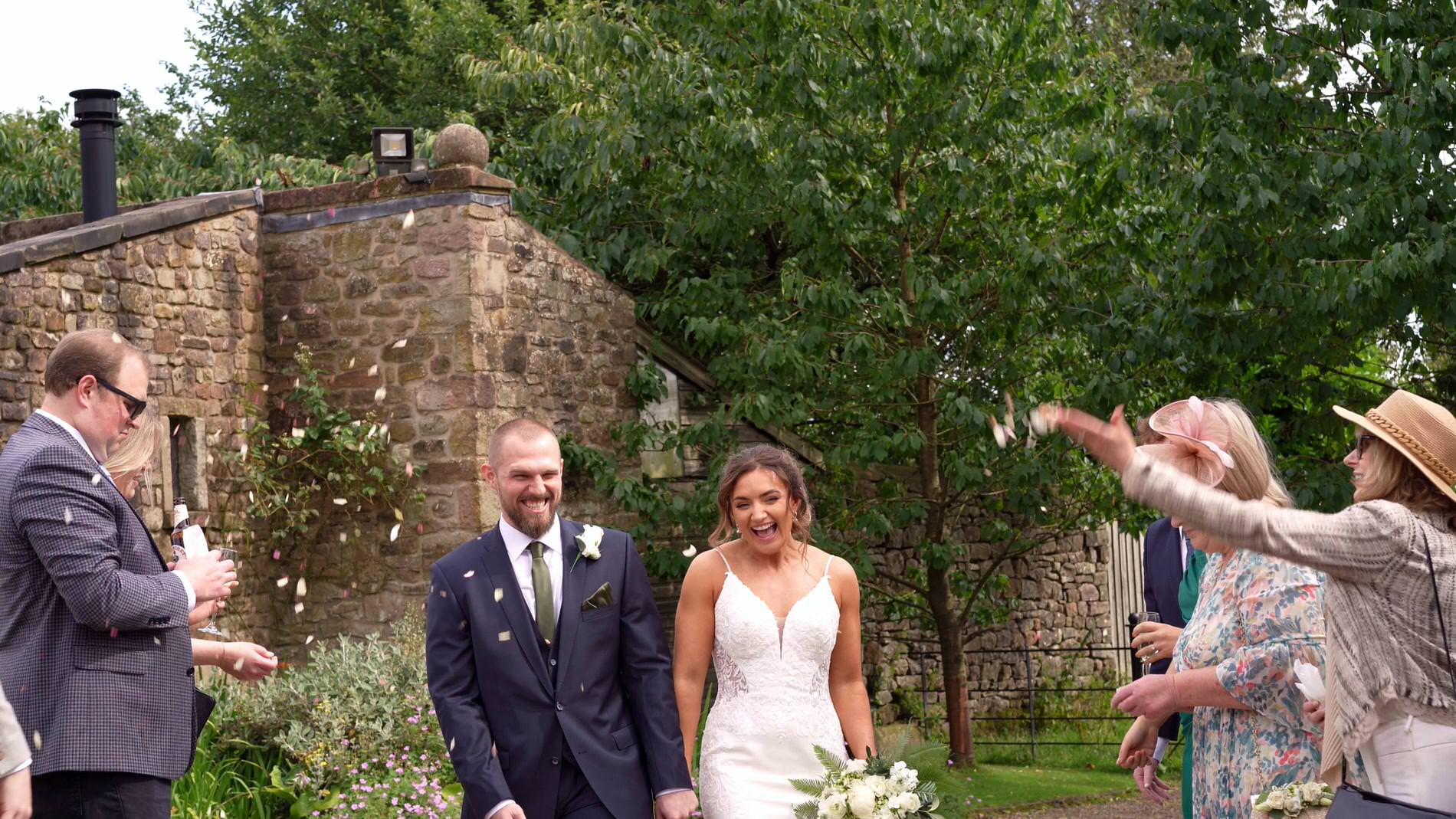 the couple laugh as their filmed for their confetti walk at Browsholme Hall