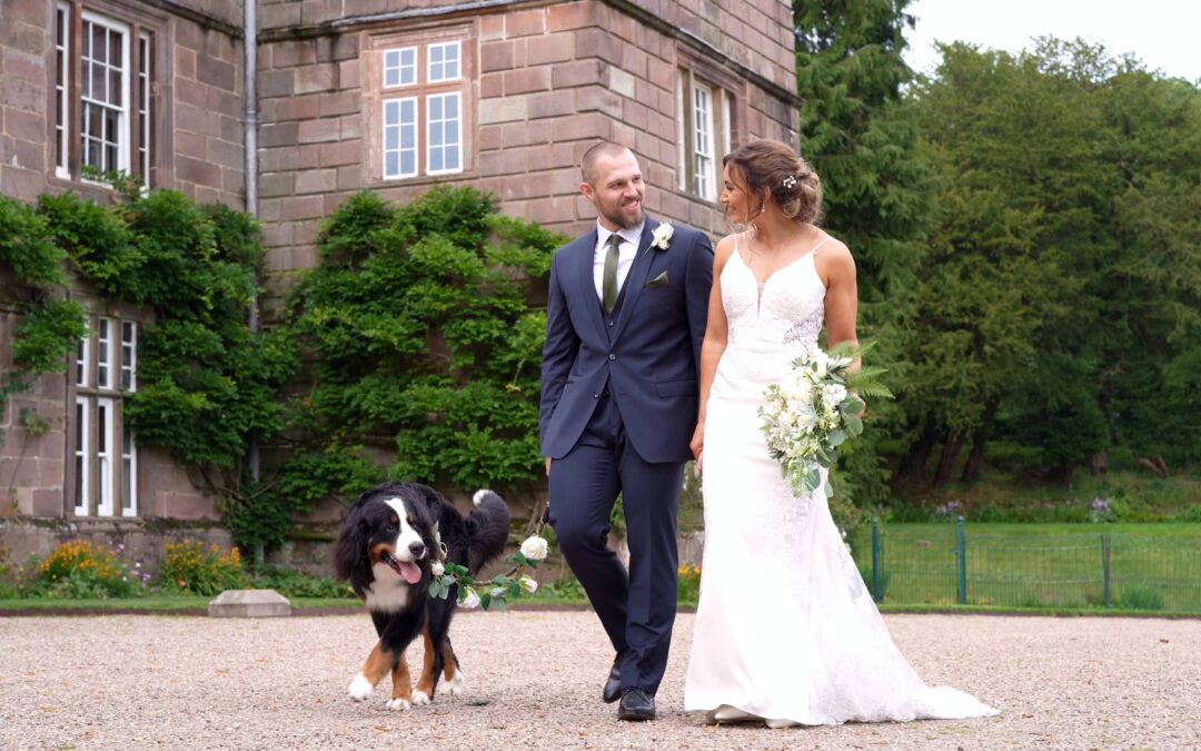 a happy couple walk with the dog outside Browsholme Hall with videographer