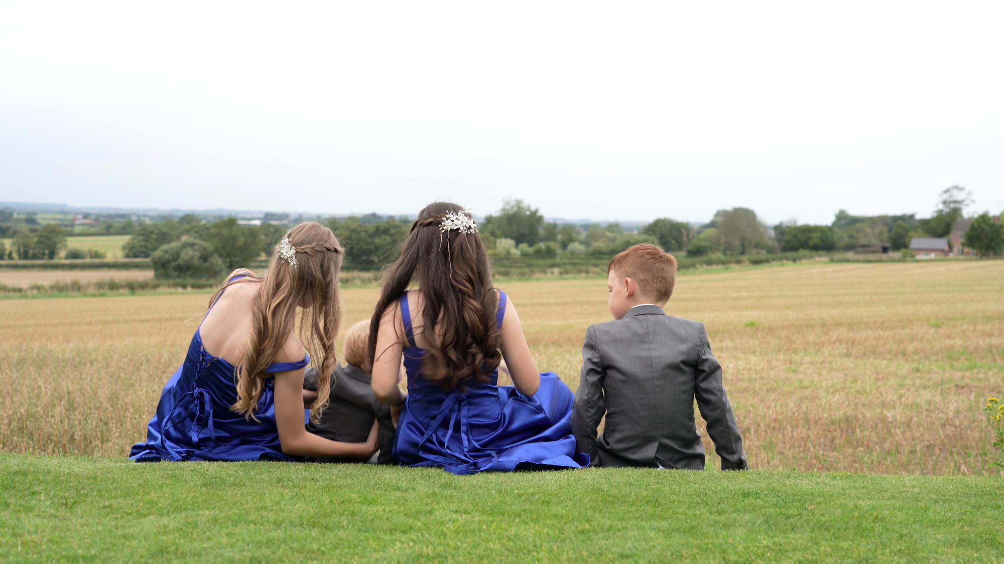 four children sit on the grass