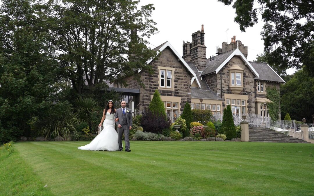 a bride and groom walk along the gardens at West Tower