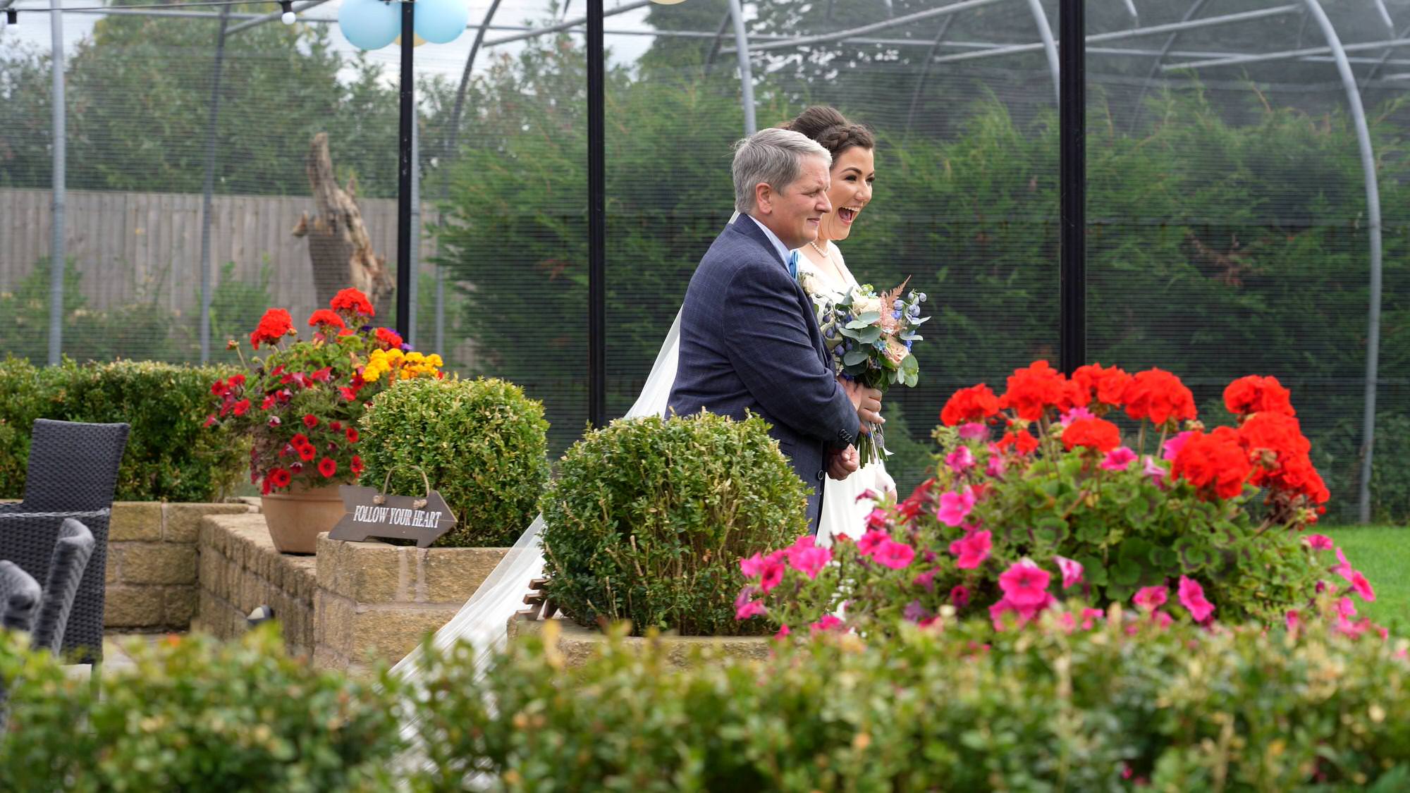 a bride walks down the aisle at The Aviary in Ormskirk outdoor ceremony