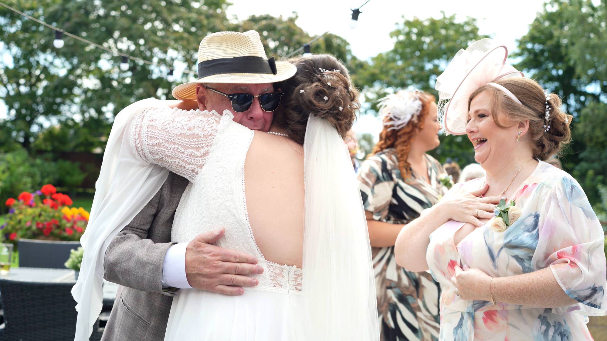 a bride hugs an emotional groom