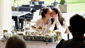 two brides kiss during wedding speeches at The Aviary in Ormskirk
