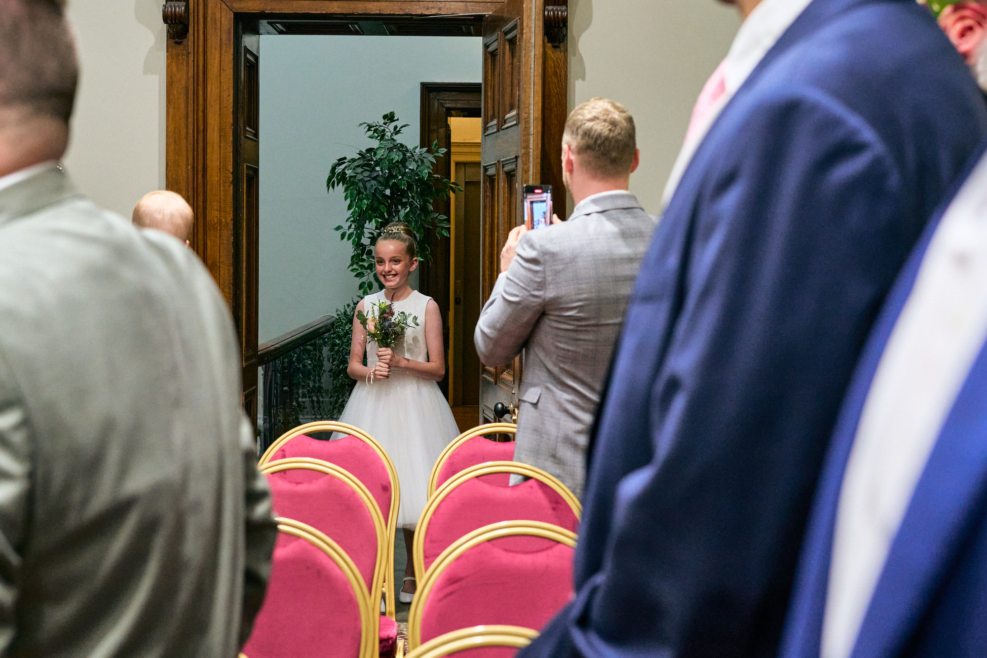 A flower girl smiles as she enters the ceremony at St Georges Hall in Liverpool