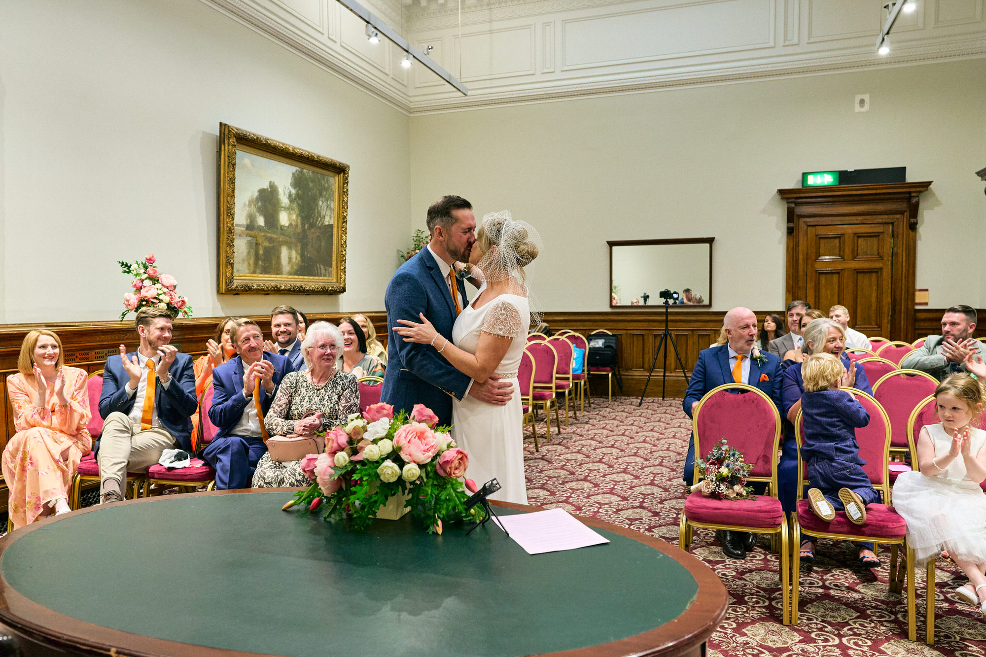 a wide angle photo of the couple kissing during ceremony in the Grand Jury Room at St Georges Hall
