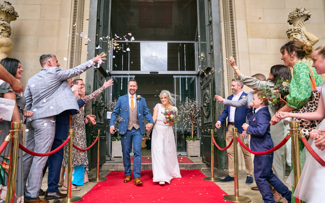 a fun and bright confetti photo outside at St Georges Hall on the red carpet