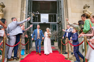 a fun and bright confetti photo outside at St Georges Hall on the red carpet