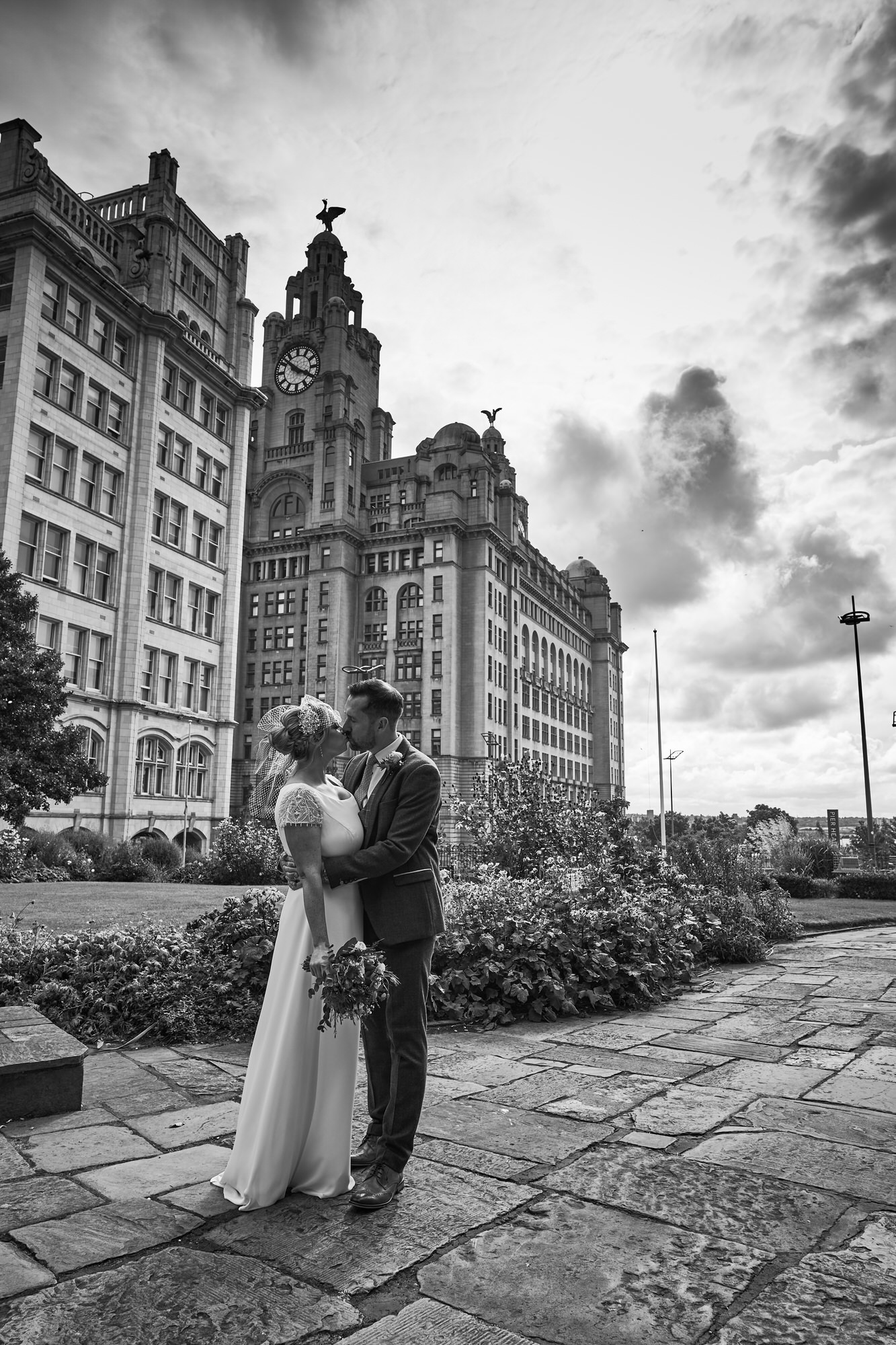a black and white photo of a couple near the Liver Buildings