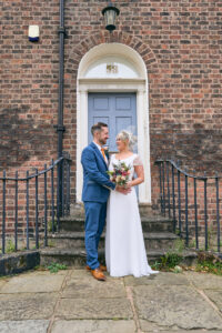 a relaxed and natural wedding portrait outside a blue door in the Georgian quarter Liverpool