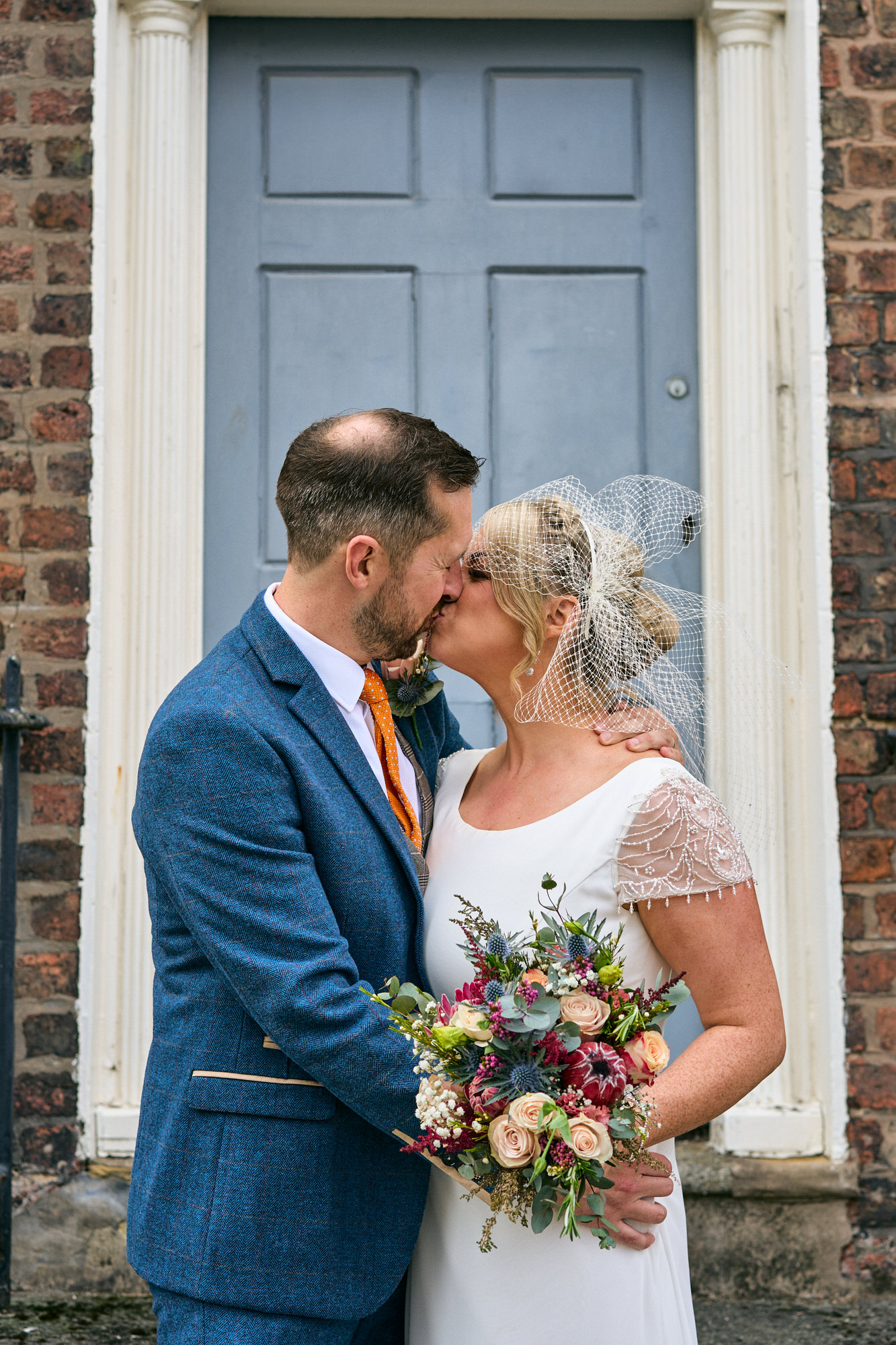 a bride and groom kiss outside a pretty door in the Georgian quarter Liverpool