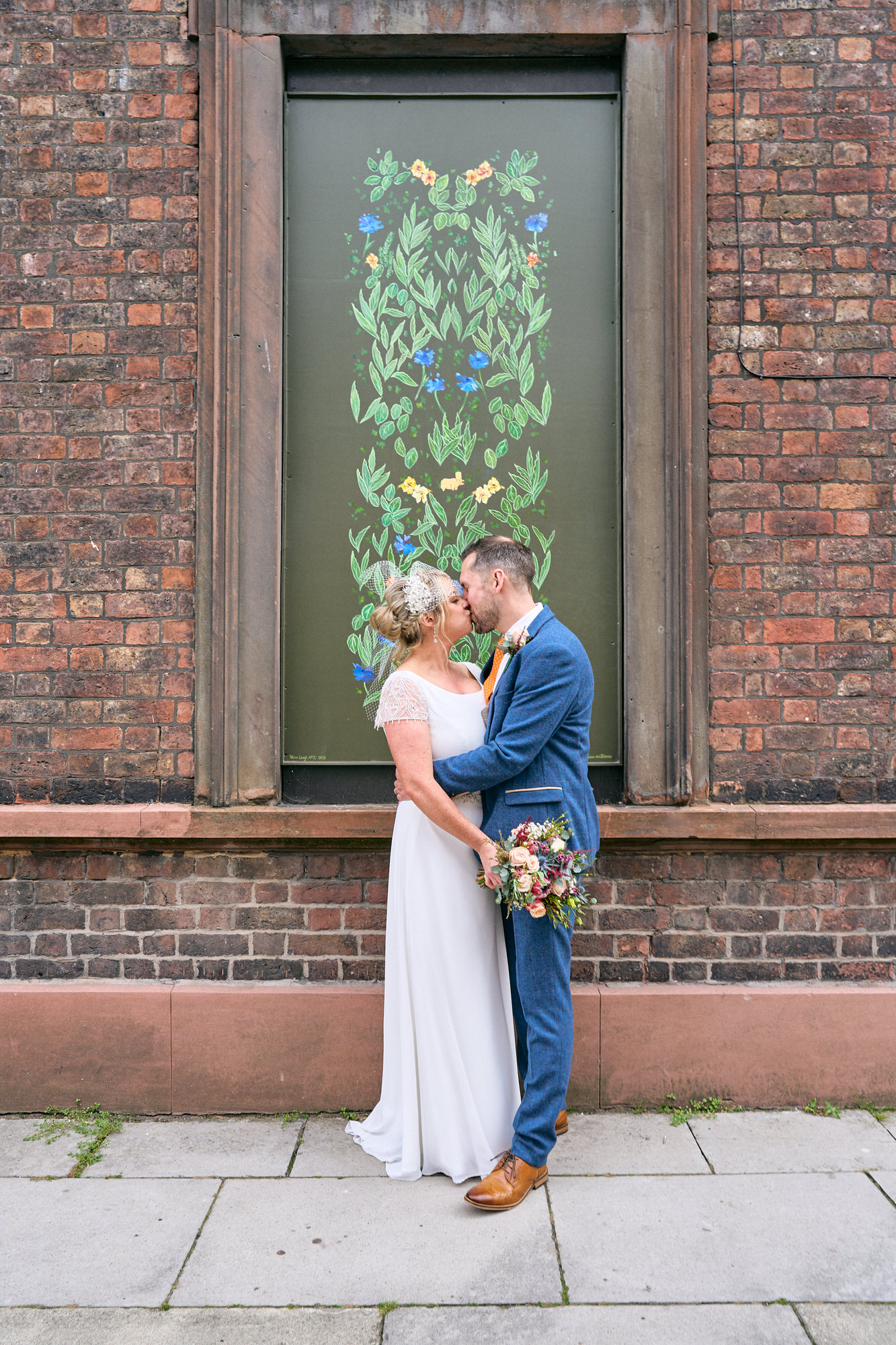 a bride and groom pose outside The Art School in Liverpool