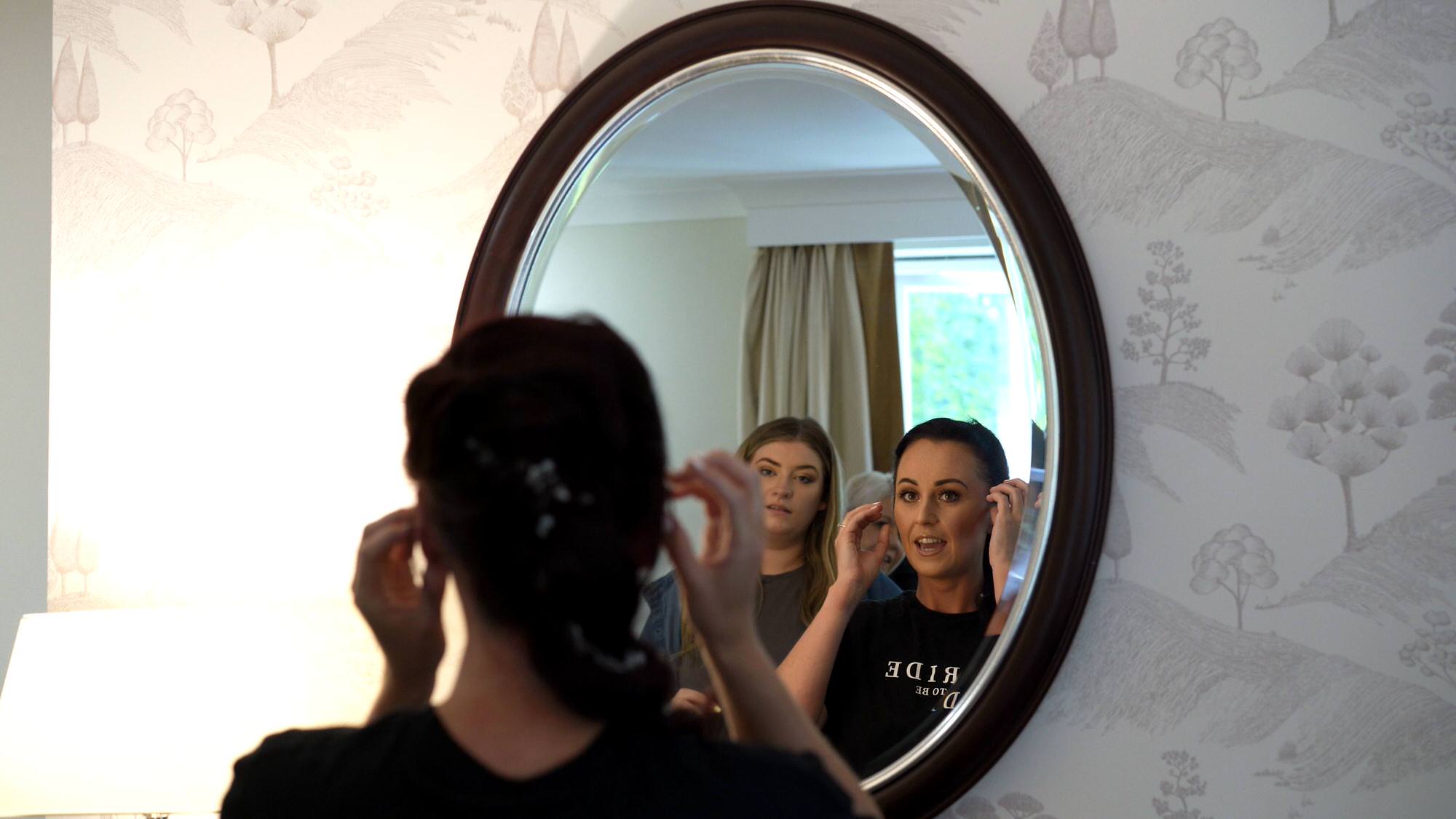 a bride checks over her wedding hair in the mirror