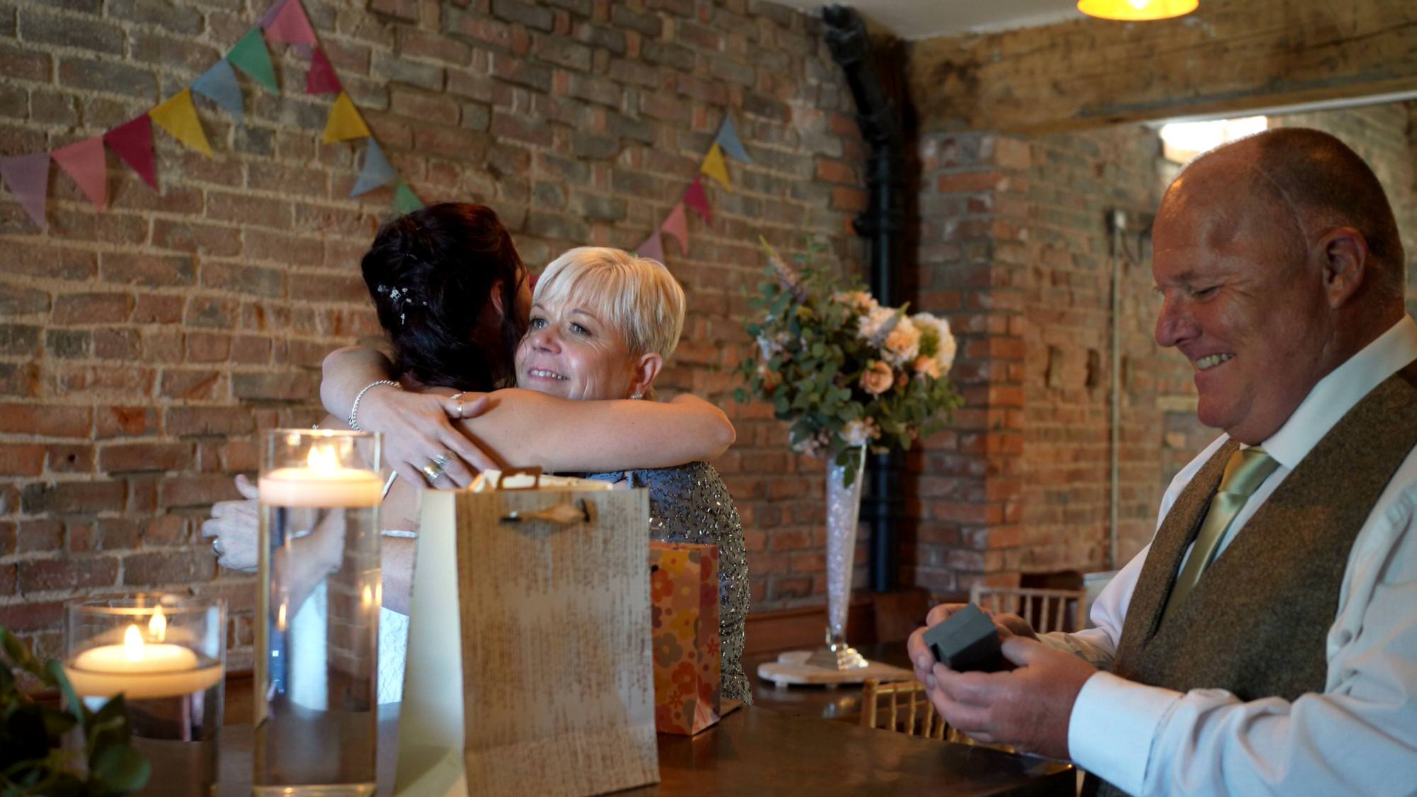 mother of the bride hugs her daughter after getting a gift