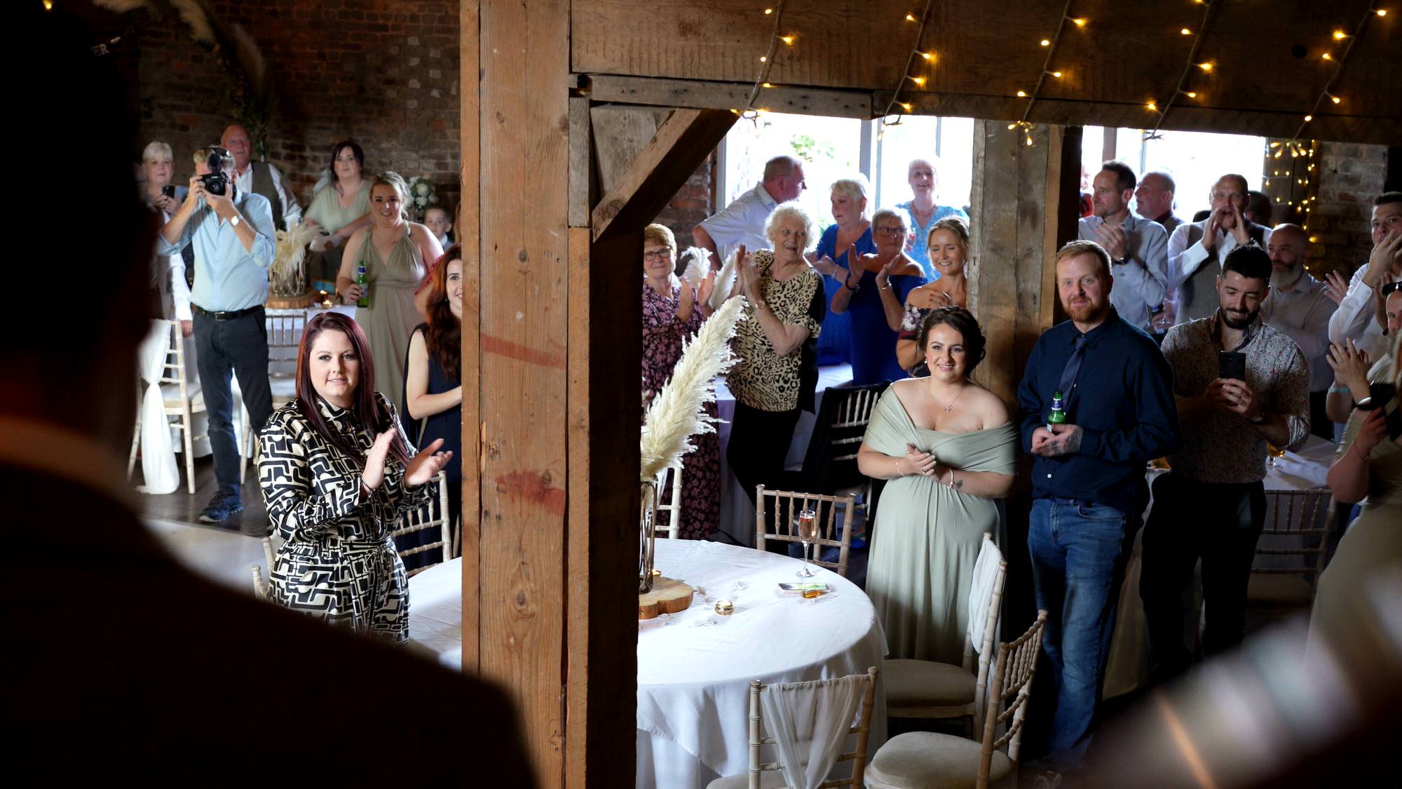 guests cheer the couple at a wedding reception at the barn at morleys hall