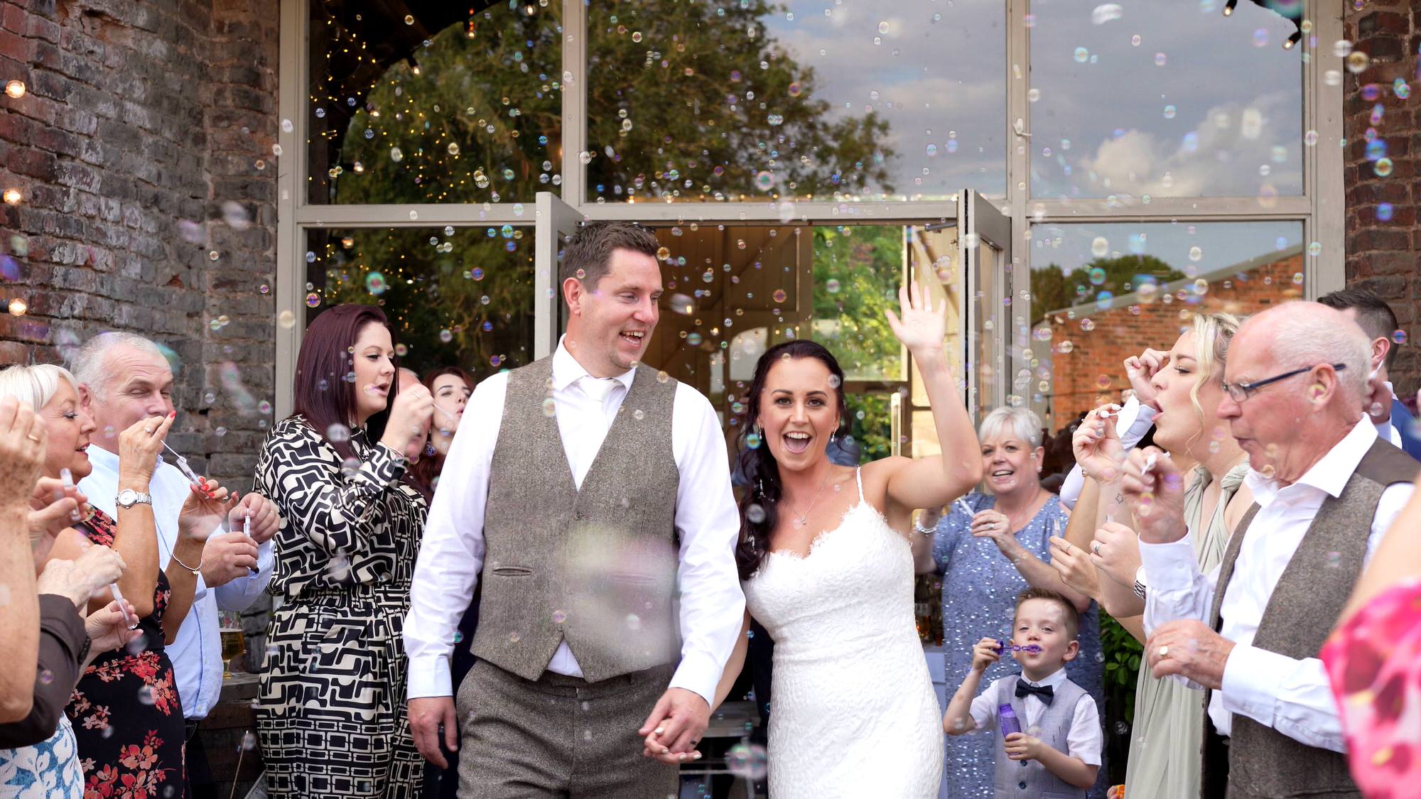 video still of a couple dancing down an aisle of bubbles outside the barn at morleys hall