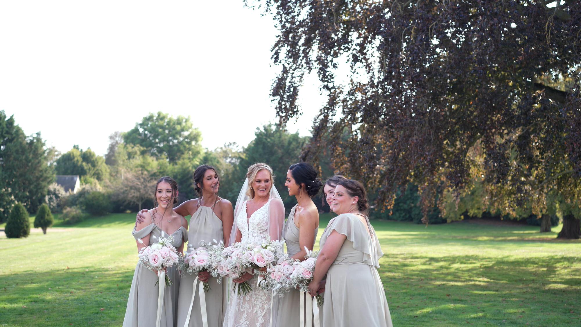 a video still of the bride posing with her bridesmaids