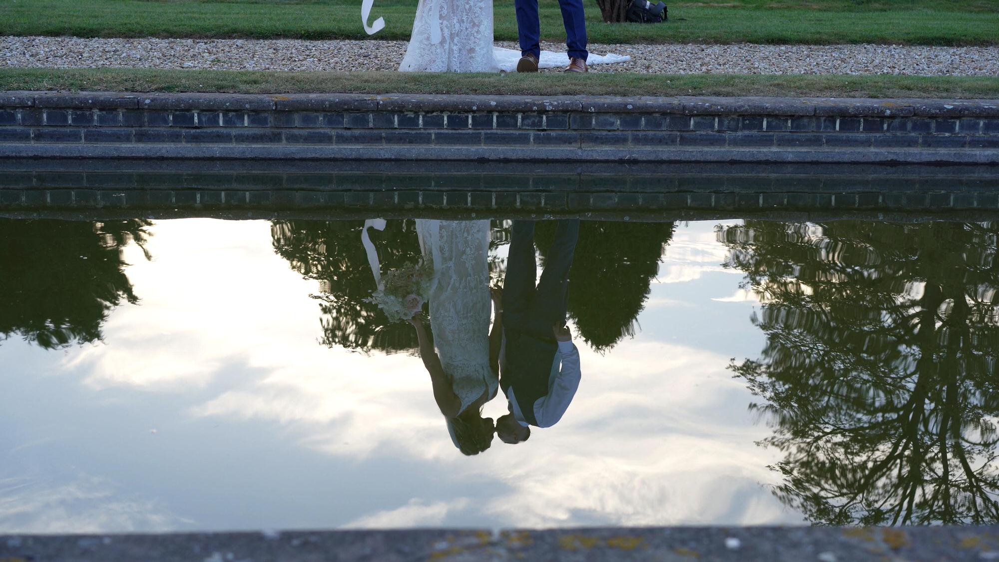 a creative video still of the couples reflection in the water at Stubton Hall Newark