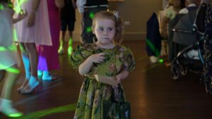 a little girl stands and eats sweets on the dancefloor