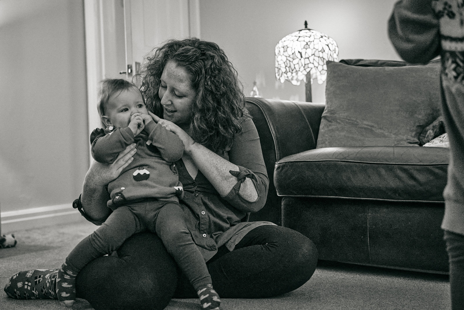 a mother kisses her baby girl on the floor at home