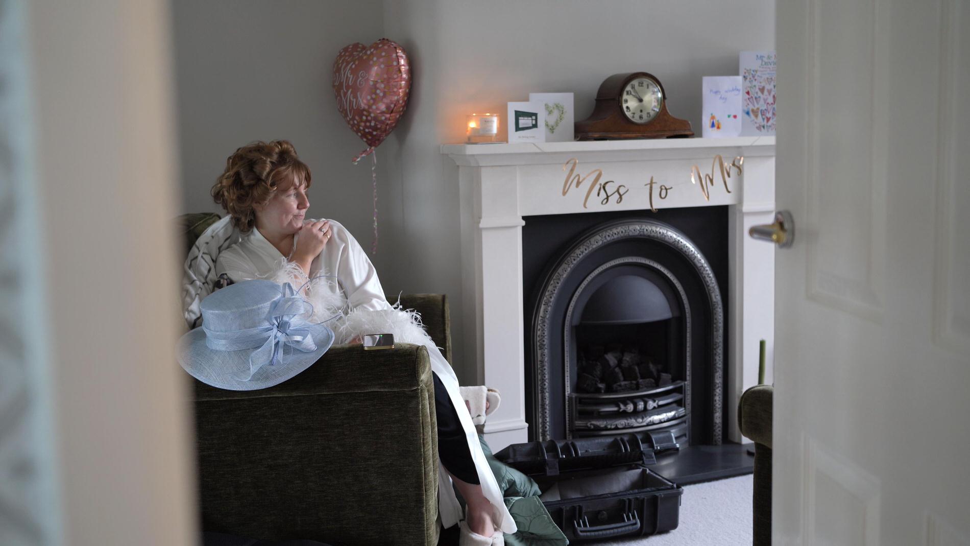 a bride chills out in hair rollers on her wedding morning