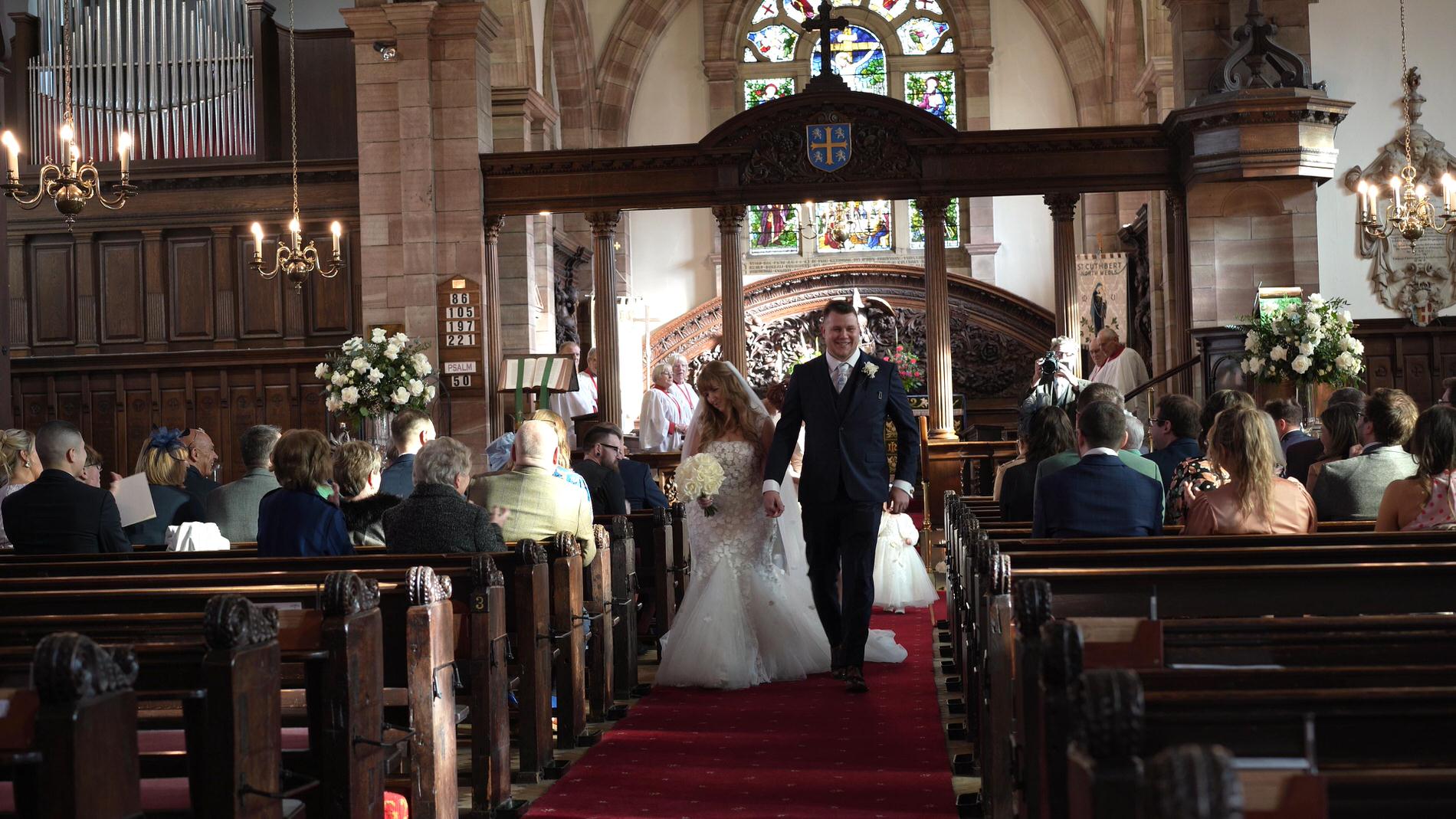 the happy couple walk back down the aisle at St Cuthberts Church in Churchtown
