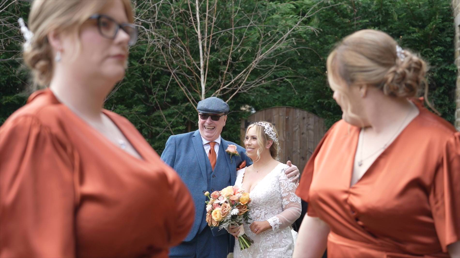 a bride waits with her dad in a flat cap outside Manor House Lindley