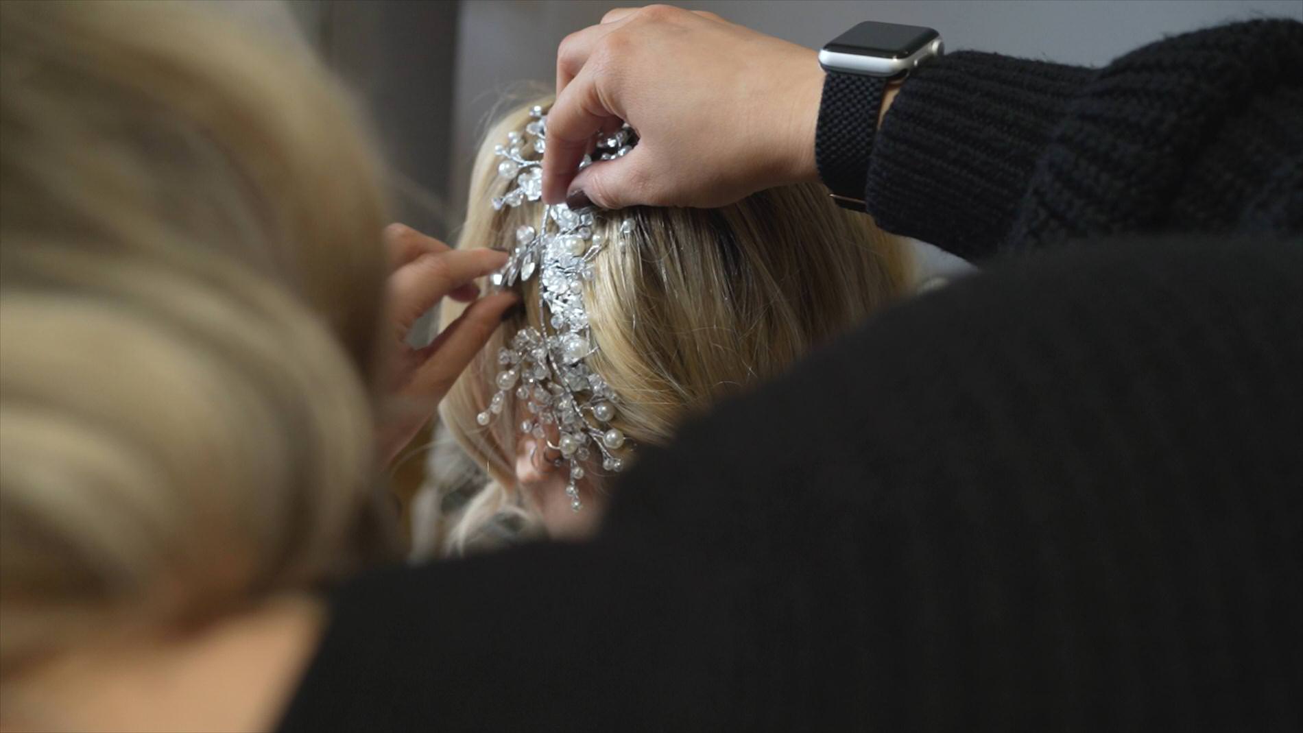 a bride has her crystal hair vine headpiece added