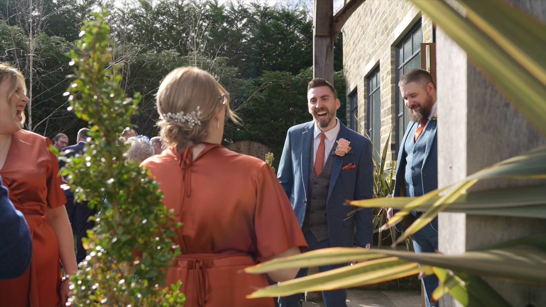 the groom laughs with guests outside Manor House Lindley