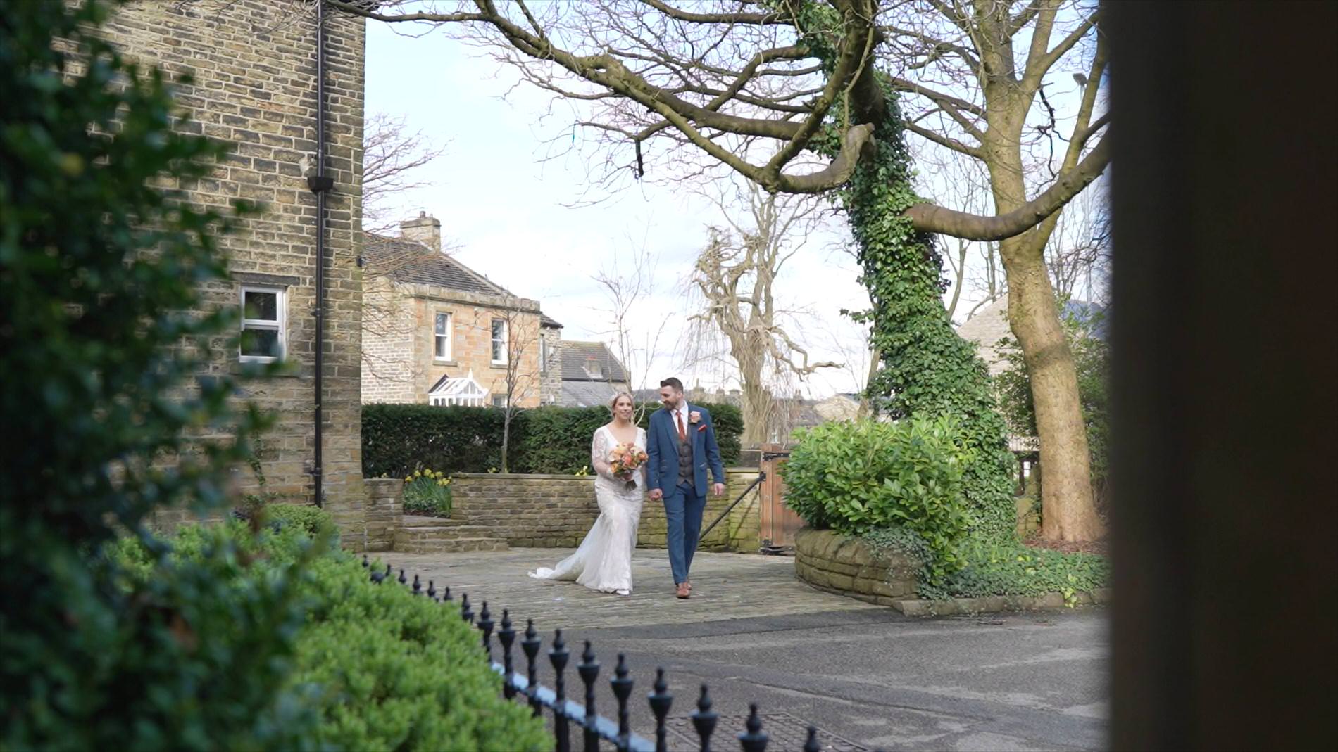 a natural moment of the couple walking outside Manor House Lindley