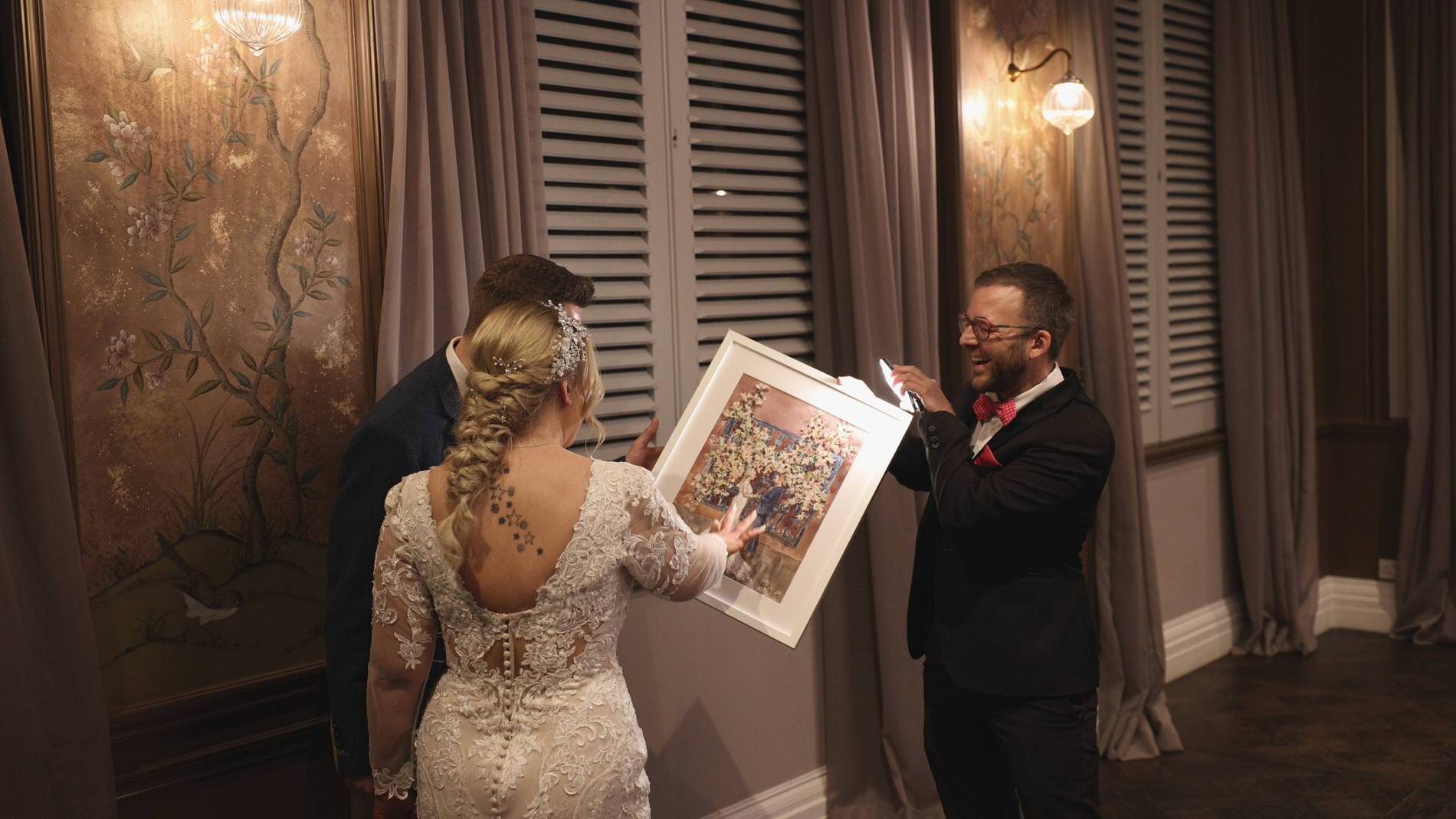 event illustrator live painter shows the finished painting to the couple at Manor House Lindley