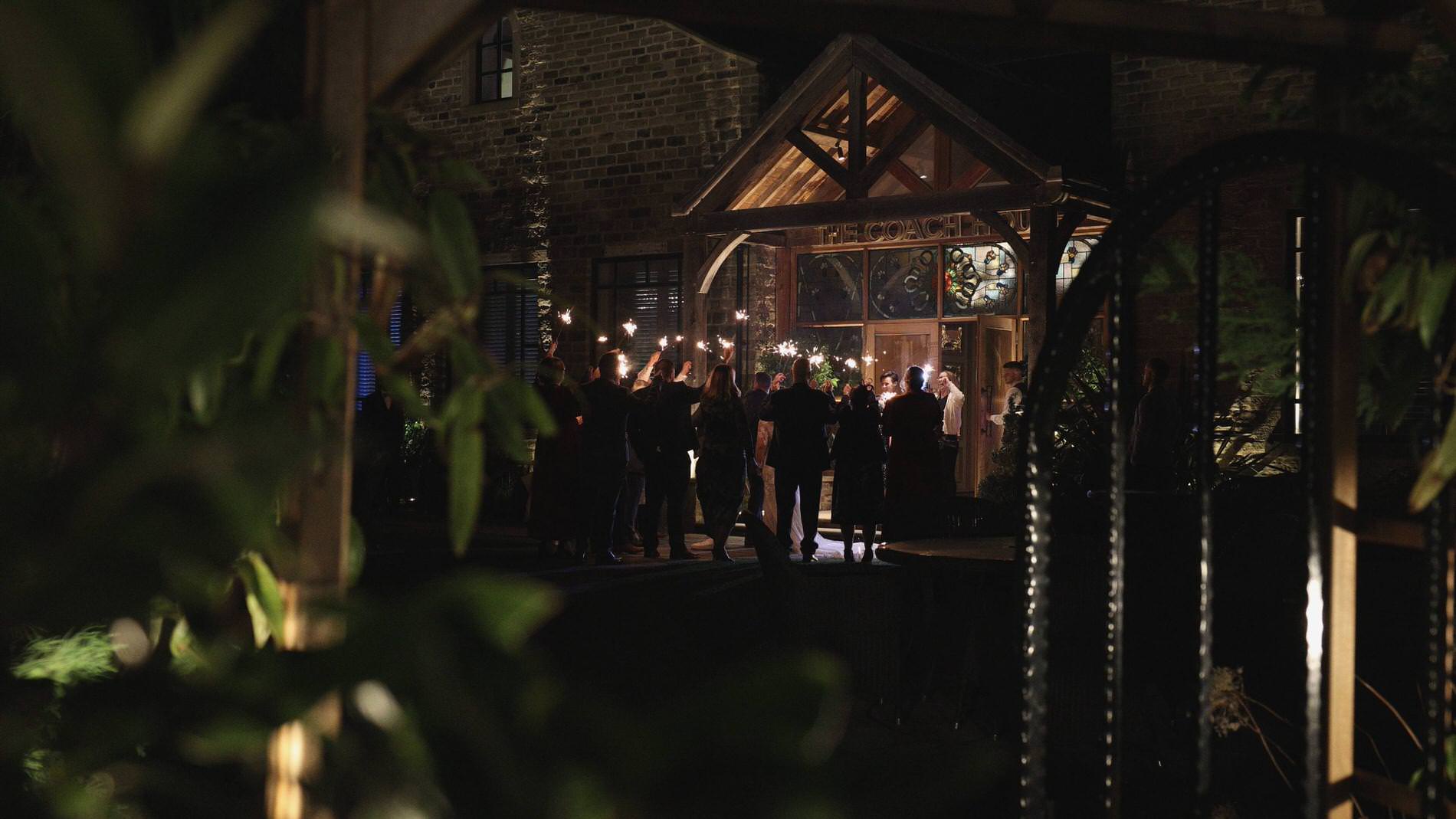 a wide video shot of guests doing sparklers outside Manor House Lindley