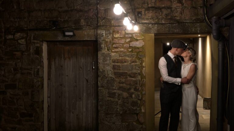 the couple pose naturally in a barn doorway outside Bashall
