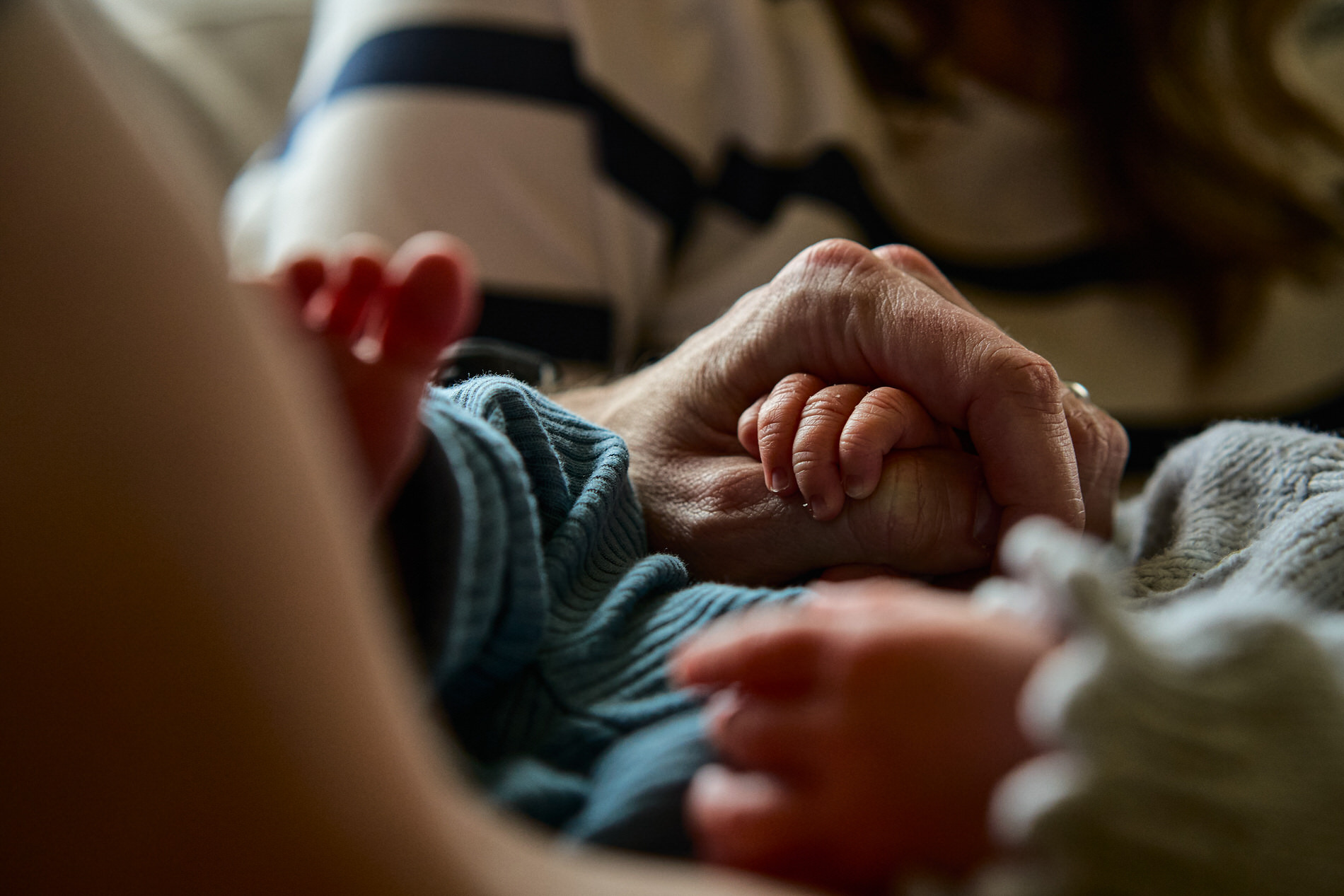 a close up photography of a baby holding dads finger