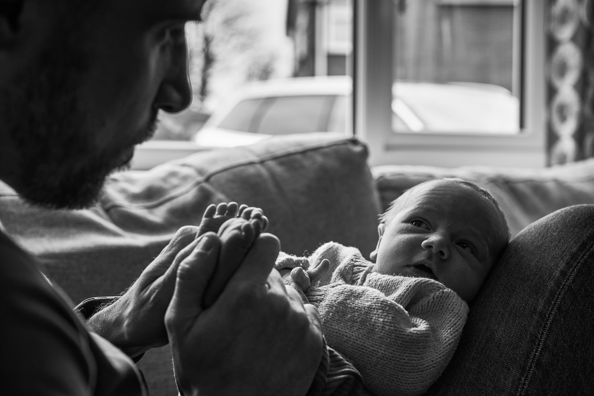 a newborn baby looks up at dad