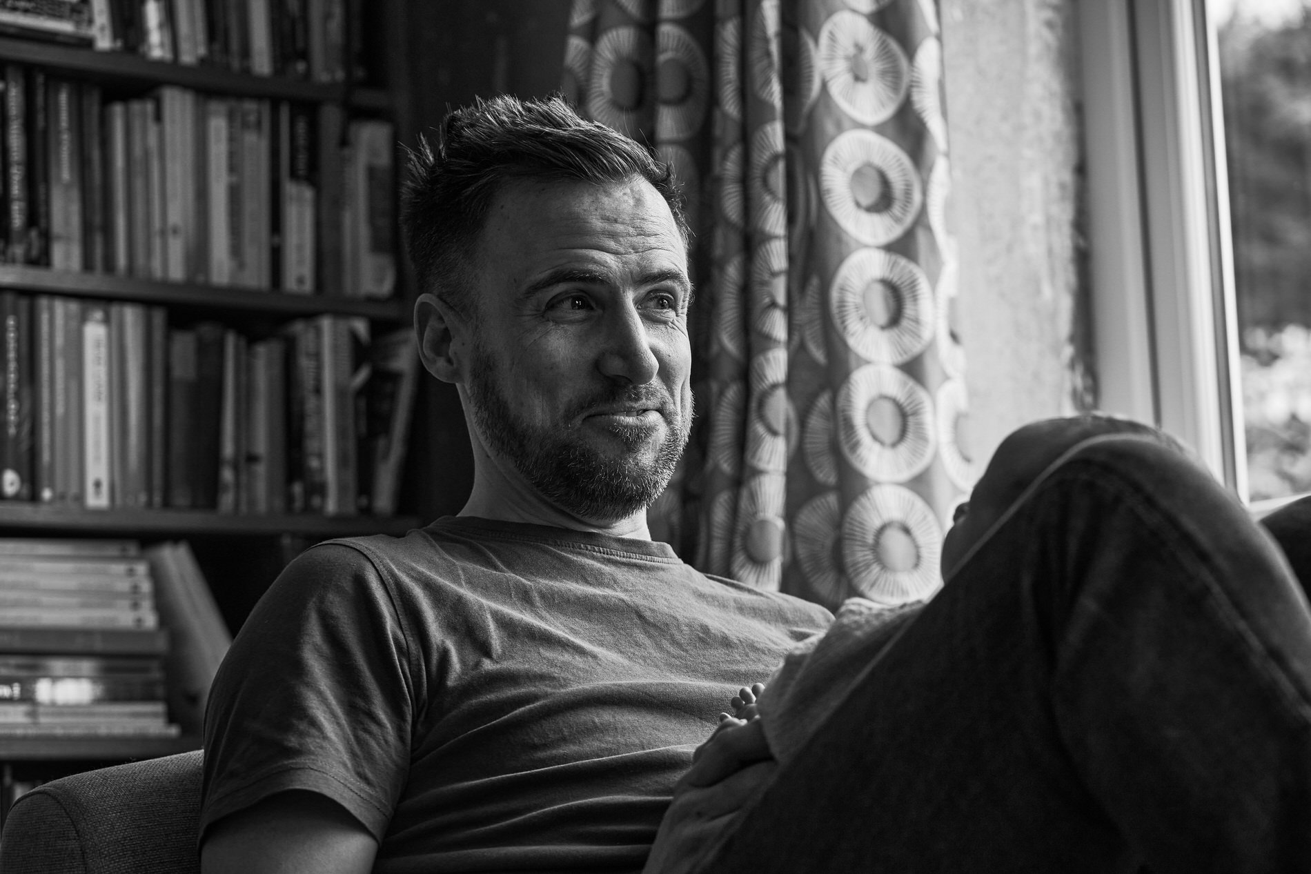 a candid photo of a parent sitting with baby at home